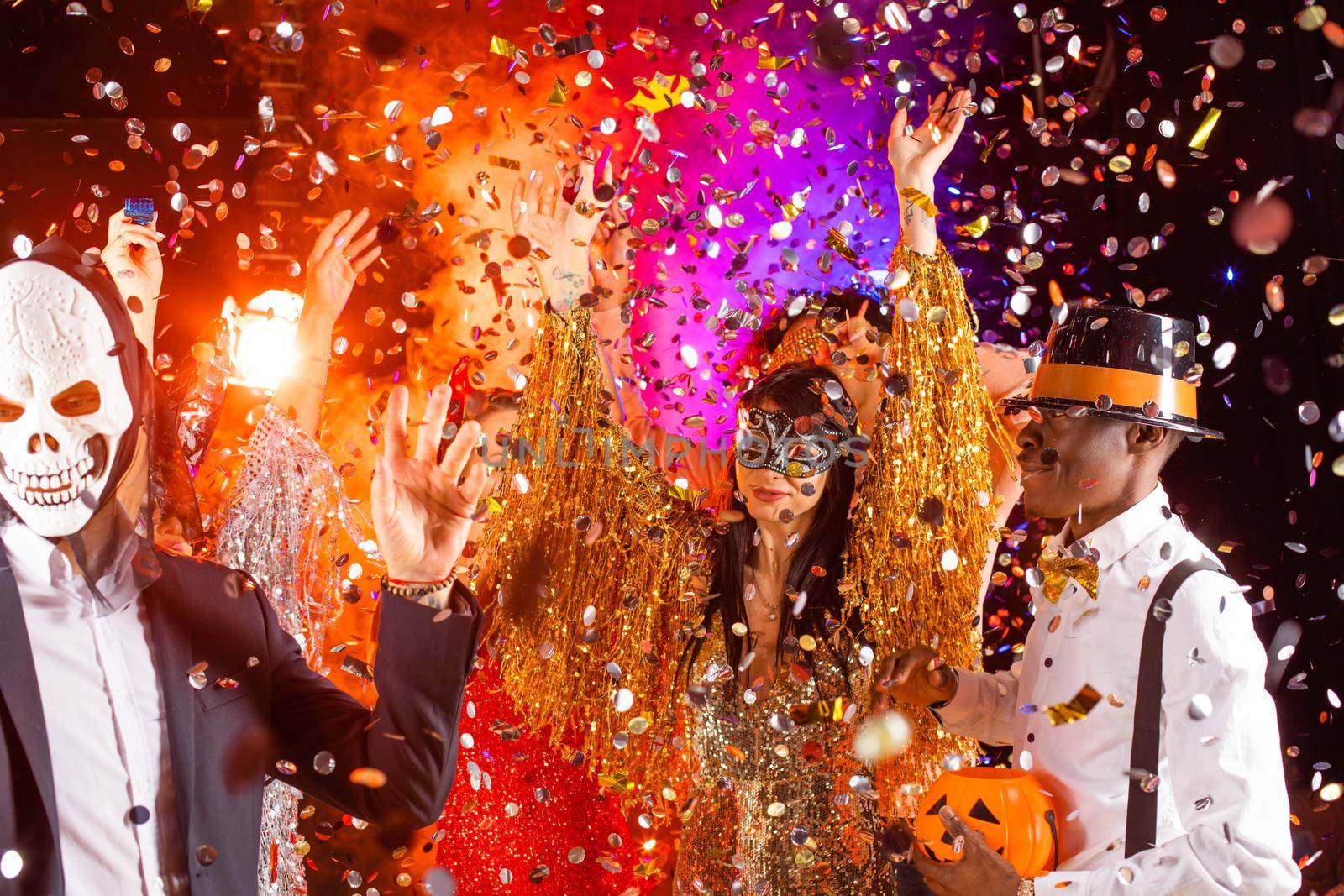 Happy people men and women mixed race dancing together on Halloween party