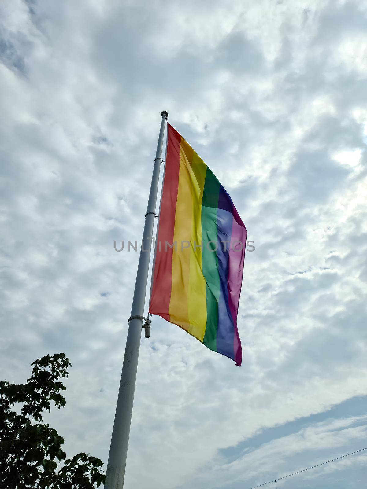 Rainbow pride flag on a flag pole. Lgbt community symbol in rainbow colors. 