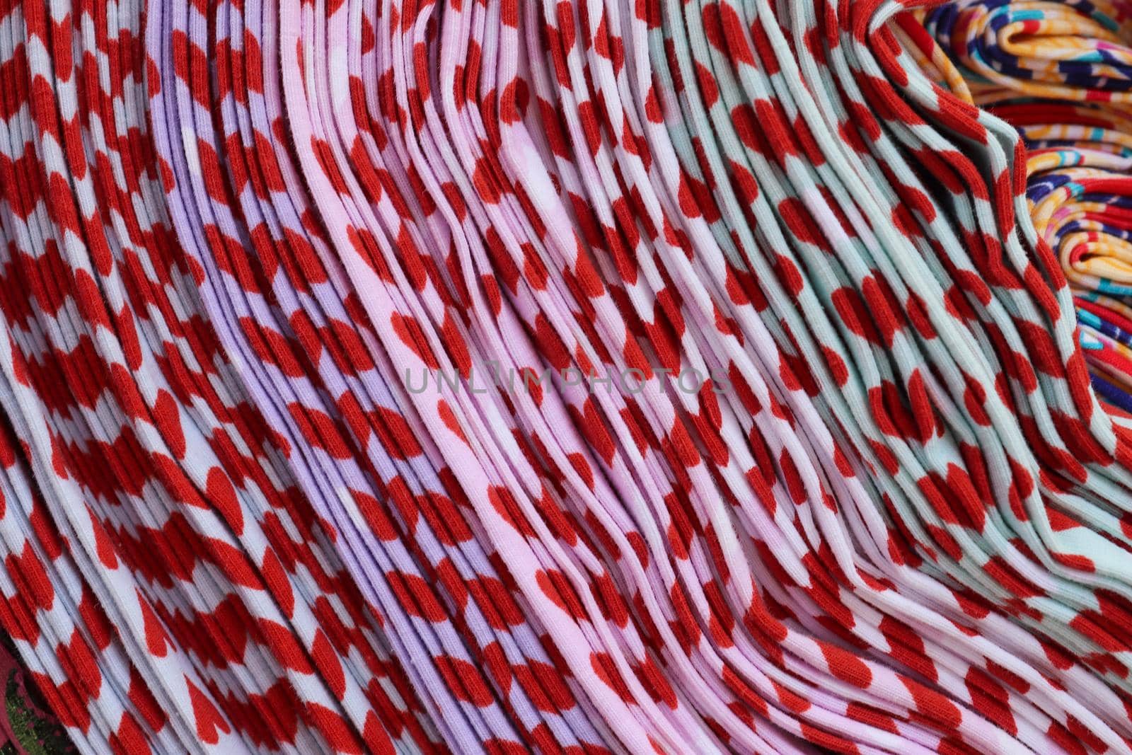 Detailed close up view on samples of cloth and fabrics in different colors found at a fabrics market.