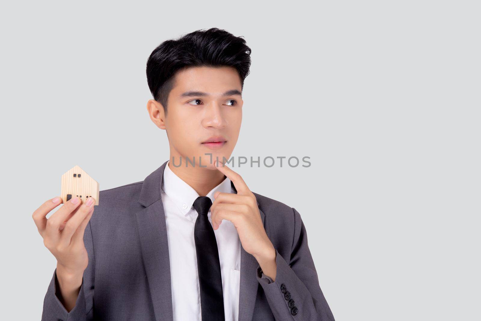 Young asian business man thinking idea and holding the home symbol of planning saving for future, insurance agent and credit, debt and loan of finance, home and refinance, investment real property.