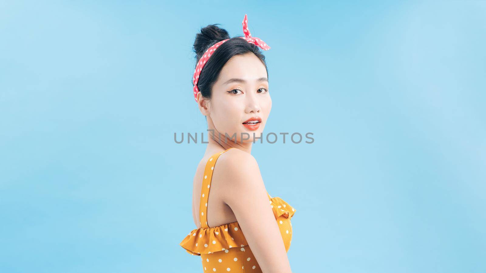 Beautiful girl in a romantic dress smiling pretty on a blue background. by makidotvn