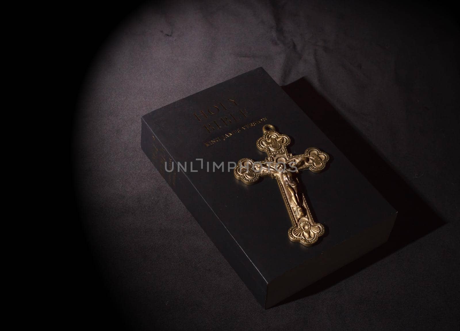 bronze cross and bible on table indoor closeup