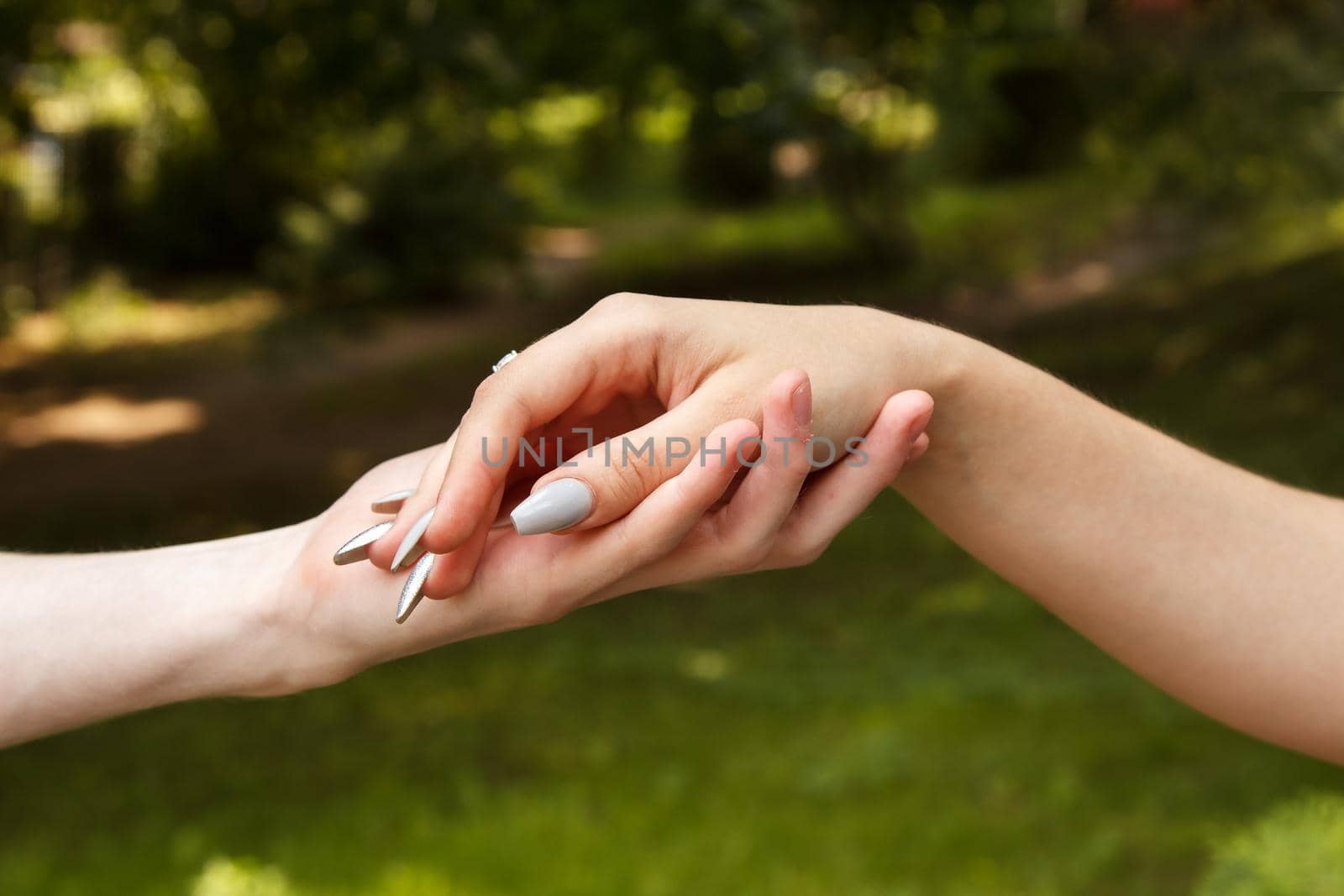 man and woman holding hands. hands closeup. outdoor on summer day