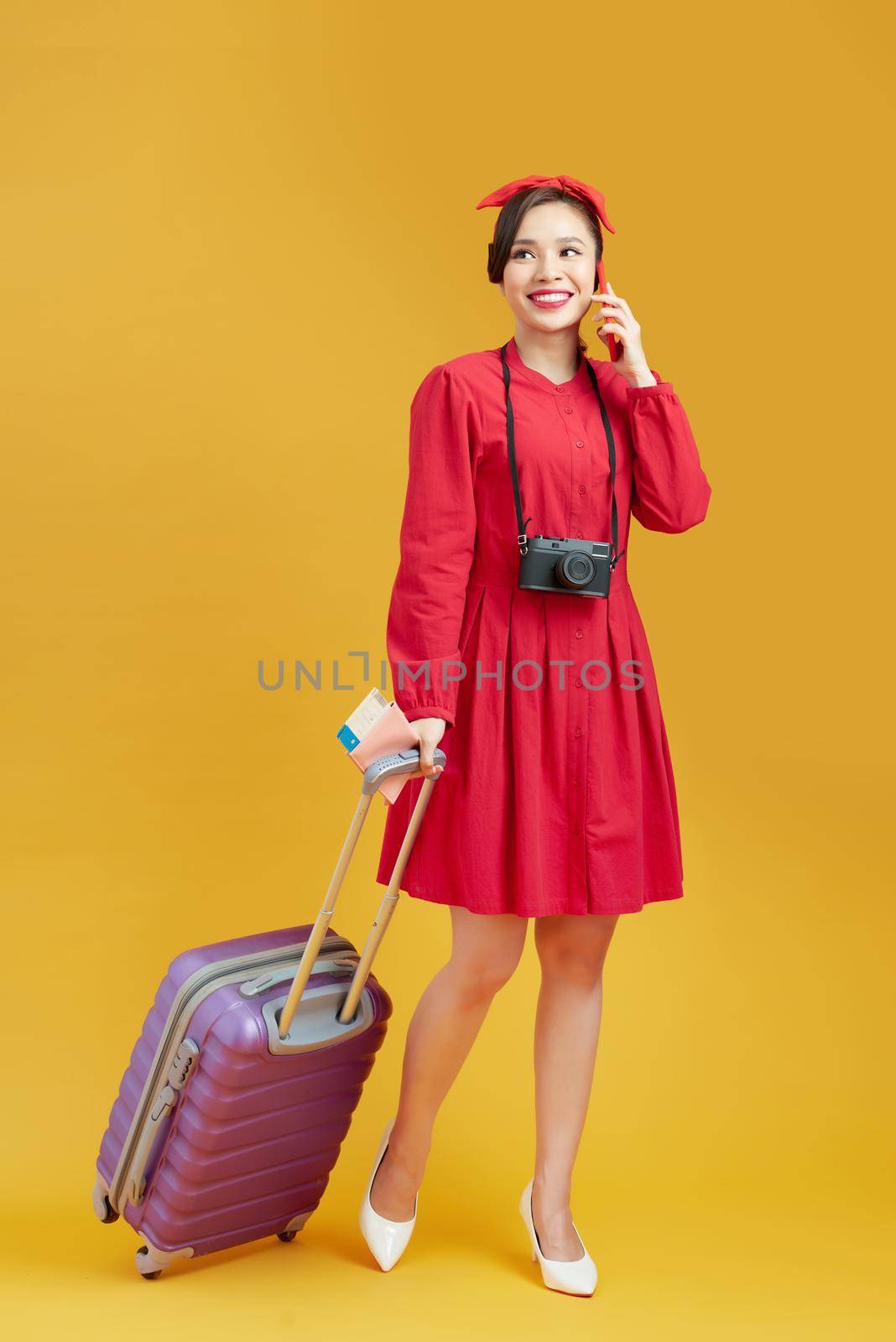 Full length of young female in casual walking with the travel bag, isolated on yellow background by makidotvn