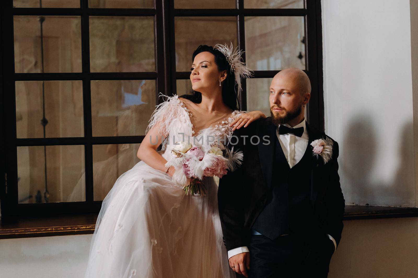 Elegant wedding couple in the interior of the old castle in the city of Nesvizh by Lobachad