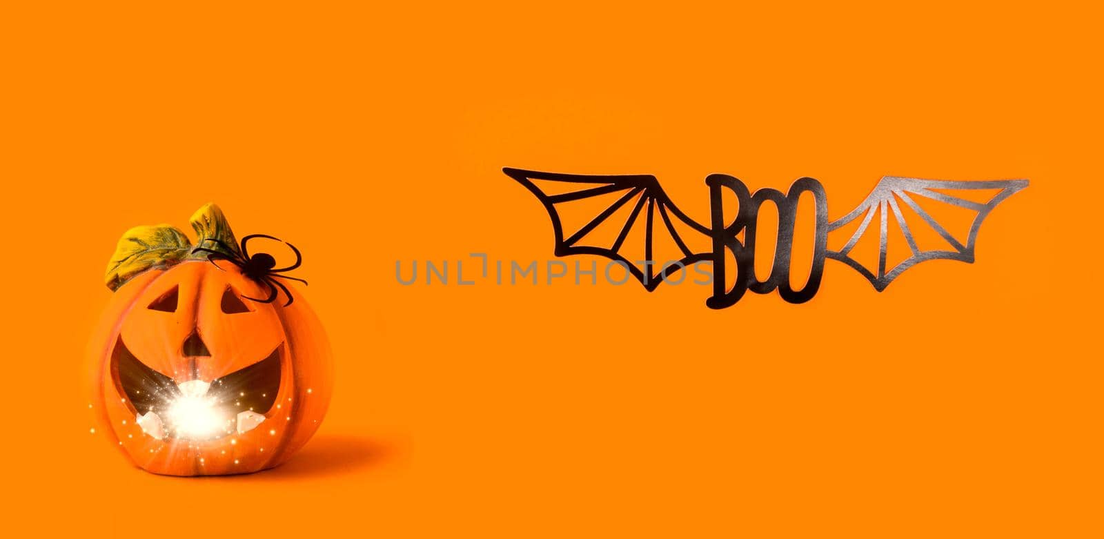 Happy halloween Holiday concept. Jack o lantern decorations with lights bokeh, spider, paper boo text on orange background. Halloween festival party, greeting banner card mockup with copy space.