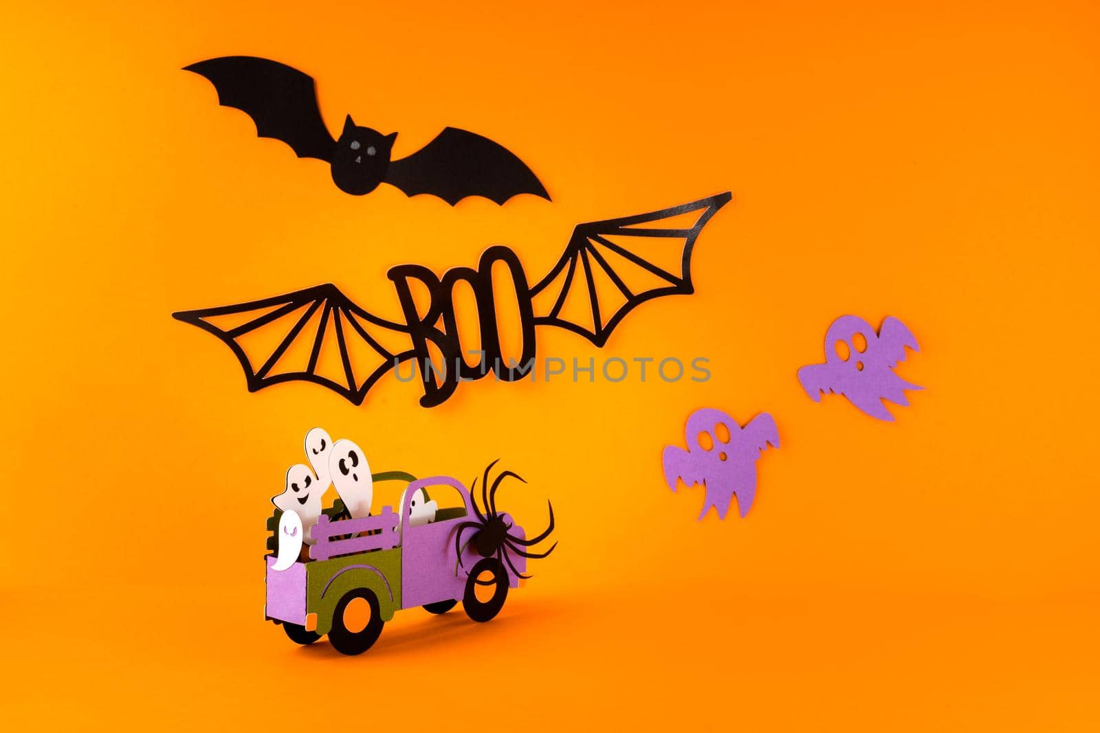 Happy halloween holiday concept. Halloween handmade paper decorations, spiders, ghosts in car, bats, boo text on orange background. Halloween festival party, greeting card mockup with copy space.