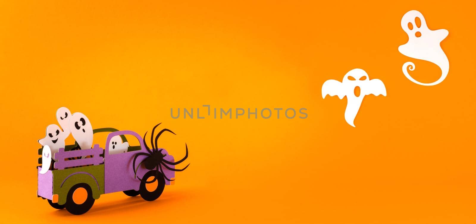 Happy halloween holiday concept. Halloween handmade paper decorations, spiders, ghosts in car on orange background. Halloween festival party, greeting card mockup with copy space.