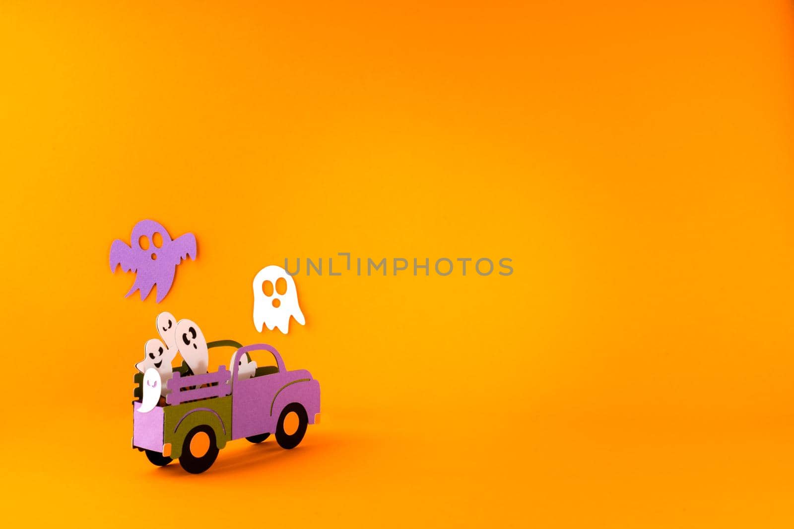 Happy halloween holiday concept. Halloween handmade paper decorations, spiders, ghosts in car on orange background. Halloween festival party, greeting card mockup with copy space by Ostanina