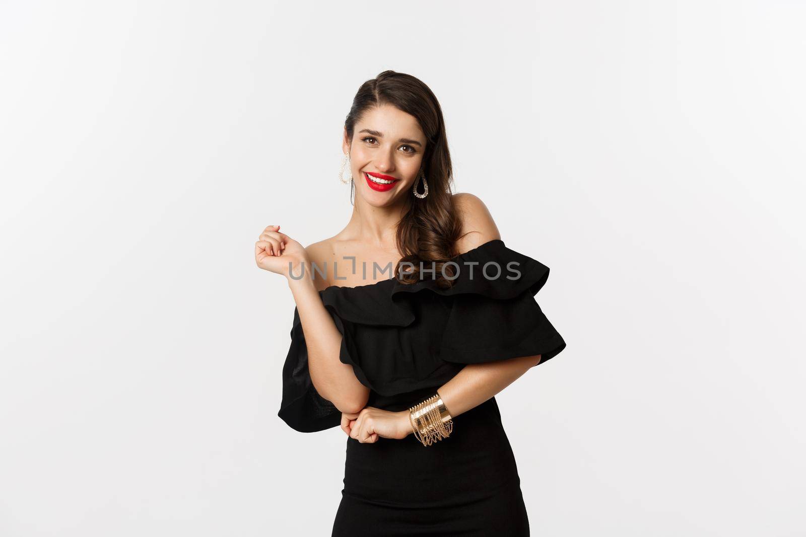 Fashion and beauty. Woman celebrating and dancing in black dress, having fun and smiling, standing over white background by Benzoix
