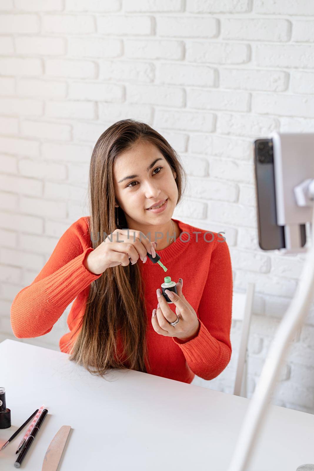 Beautiful caucasian nail master influencer having video chat or making a blog by Desperada