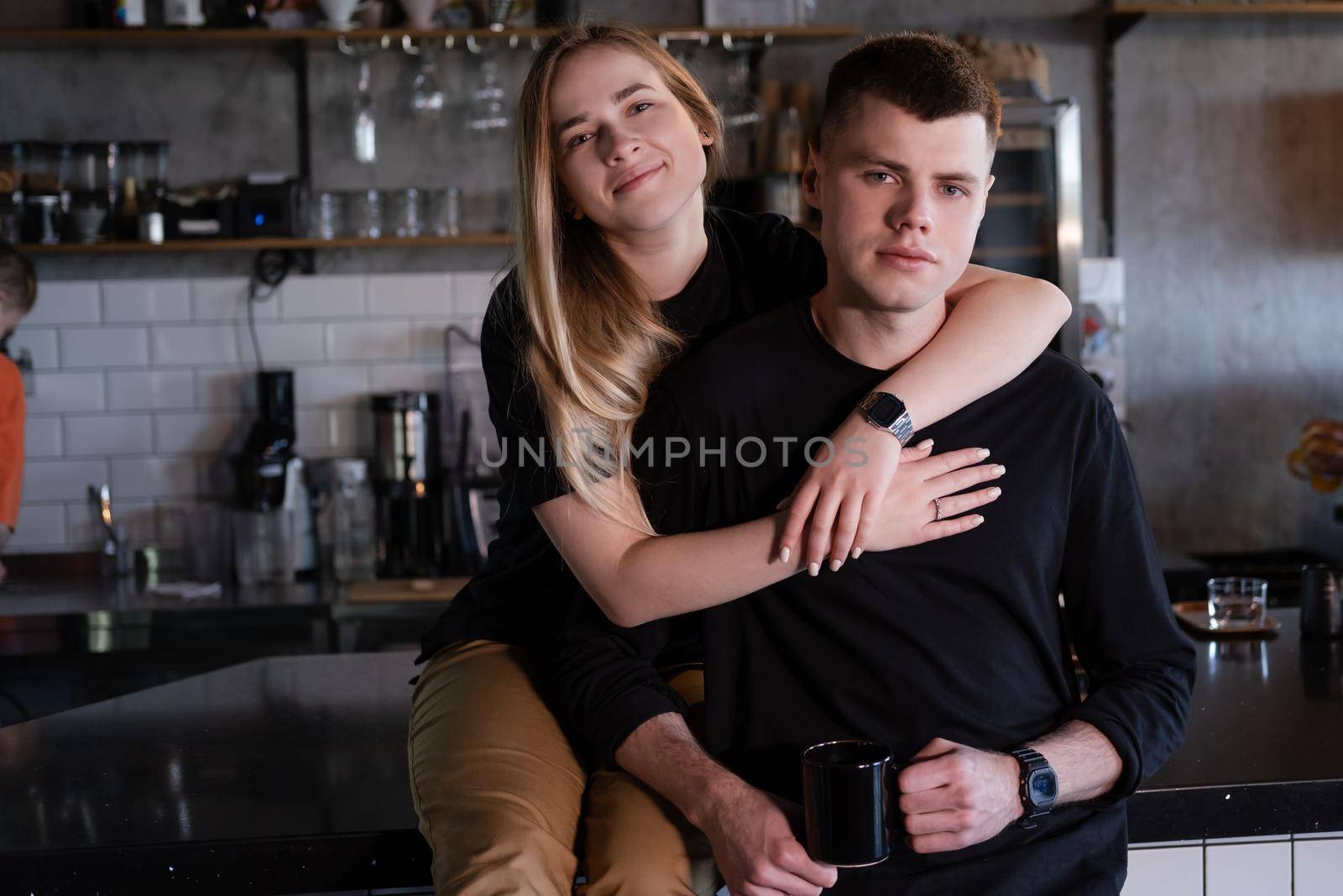 happy married couple in identical clothes family look - cafe owners or workers - in modern coffee shop. family business. loft cafe by oliavesna