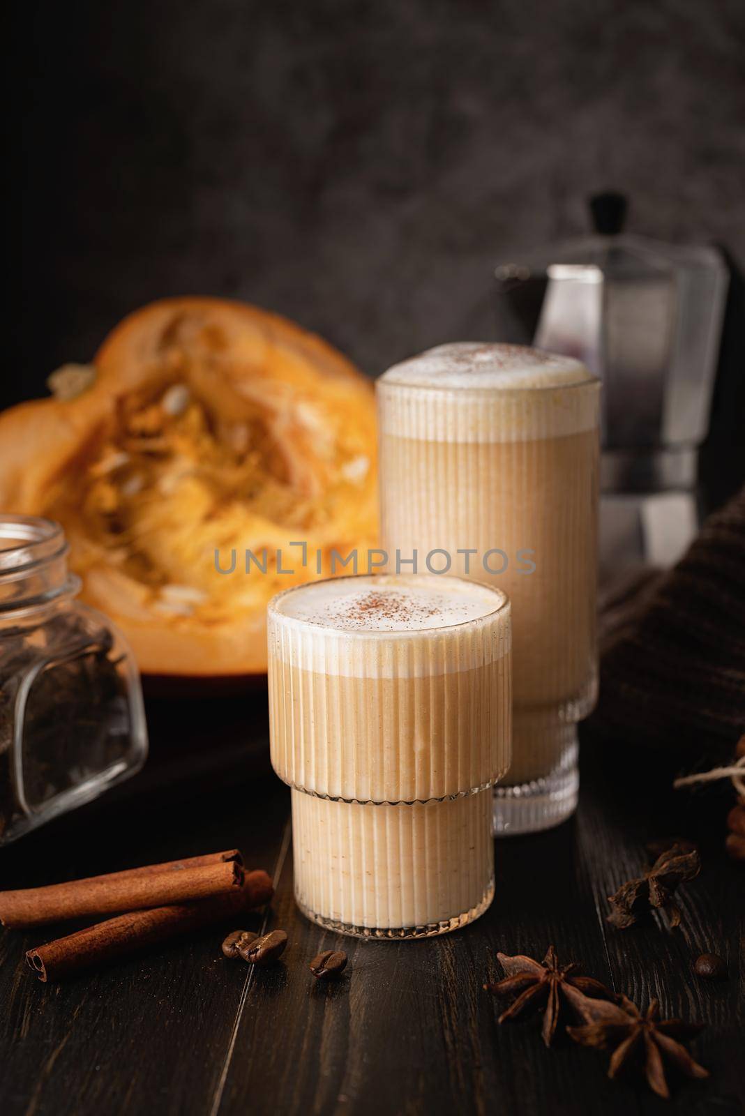 Autumn food and drink. Seasinal drinks. Pumpkin spicy latte with cream and spice, front view, dark background