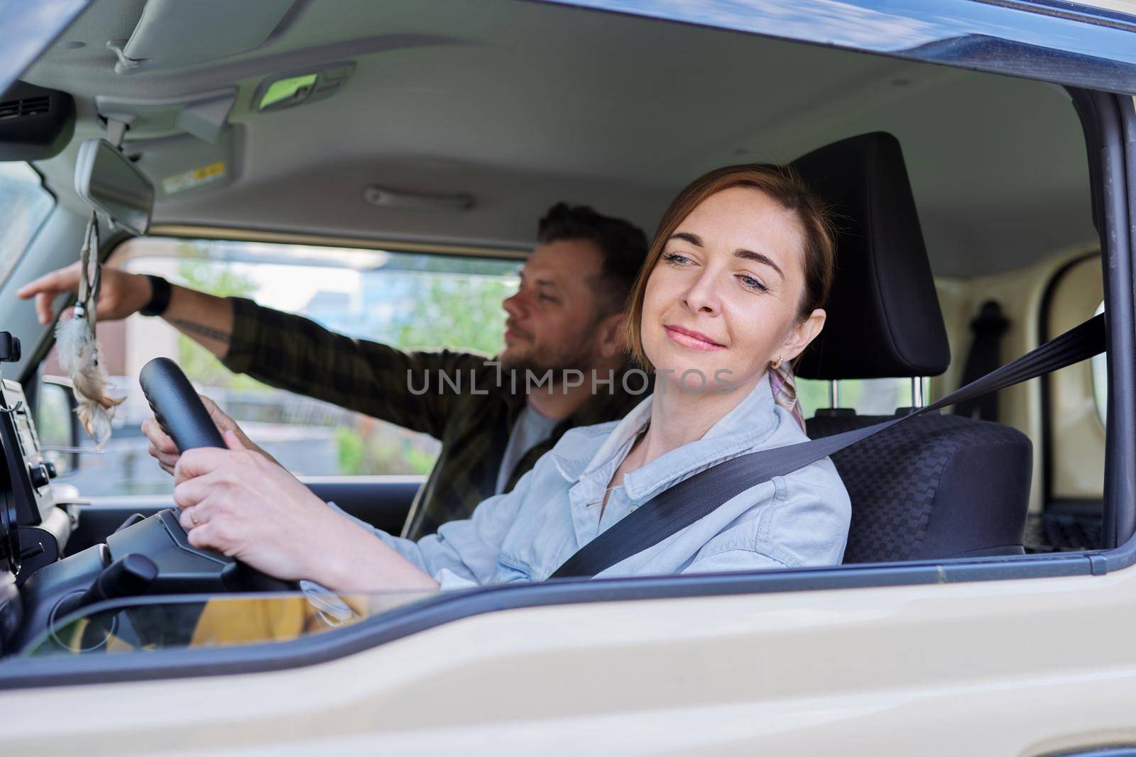 Middle age couple riding in car, woman driver man in passenger seat by VH-studio