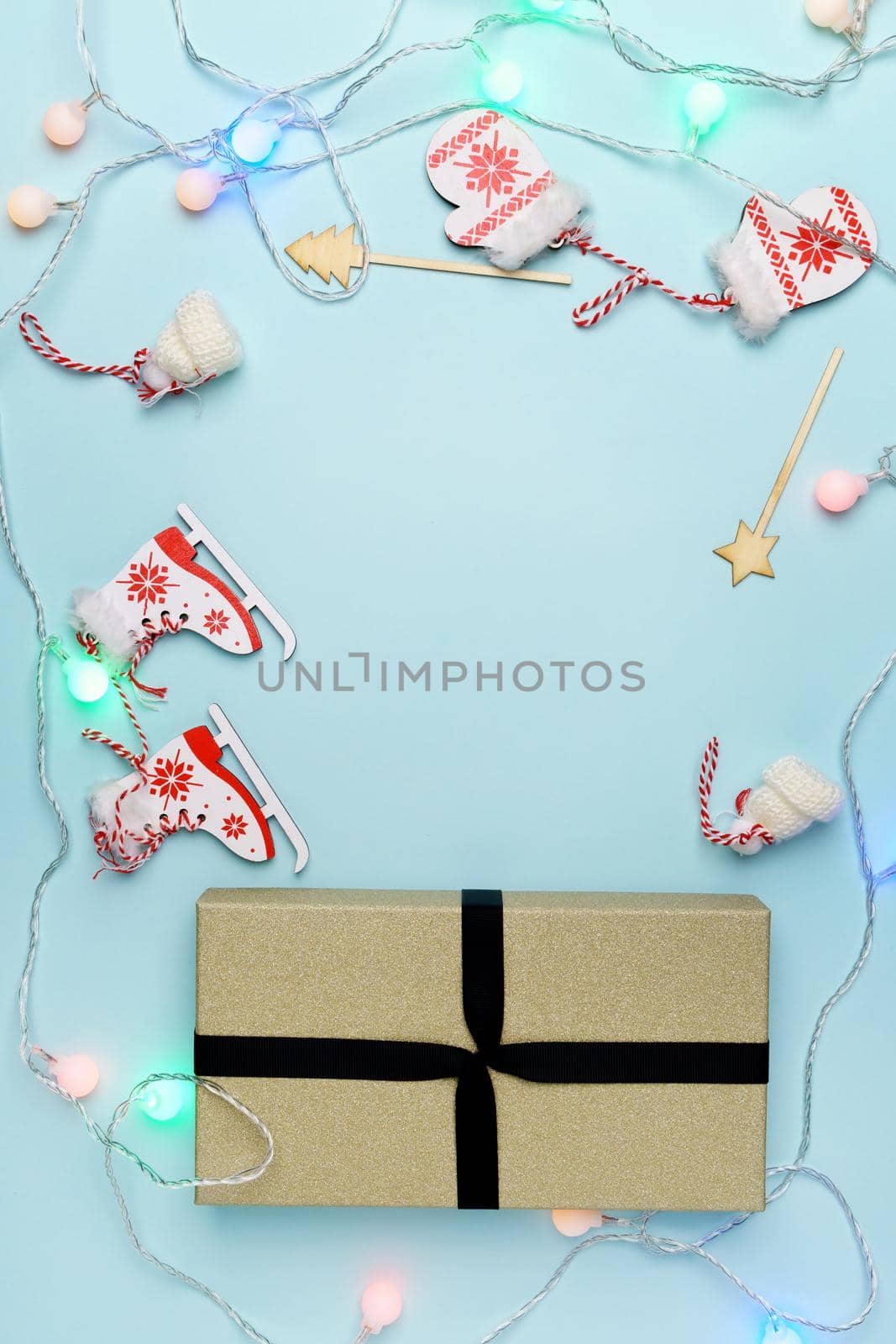 Gift box and festive decorations on light blue background. Christmas composition with copy space. Pastel colors by darksoul72