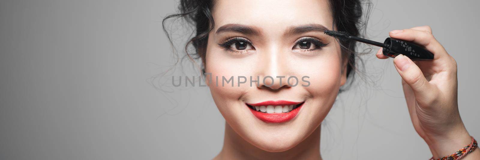 Beauty concept, asian woman with closed eyes holding mascara near eyes