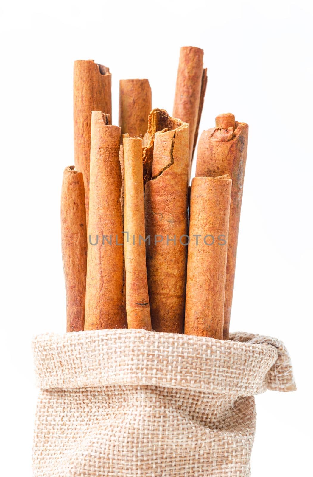 Cinnamon sticks in sag bag on white by Gamjai