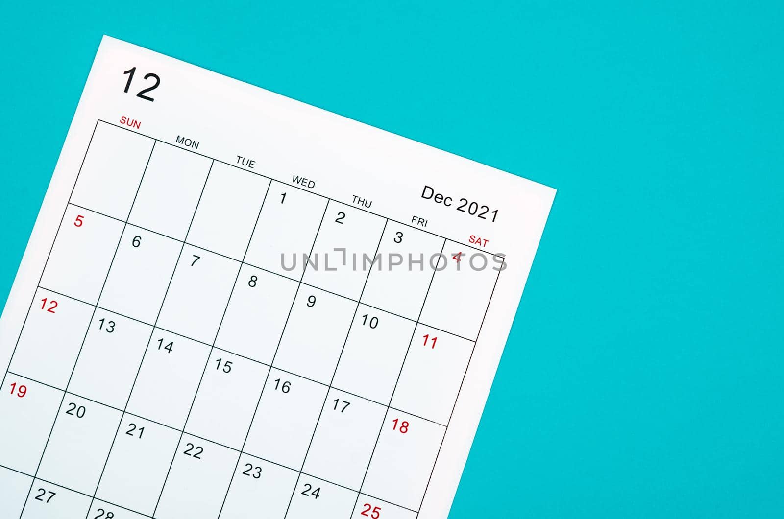 Close up December 2021 calendar sheet on green background.