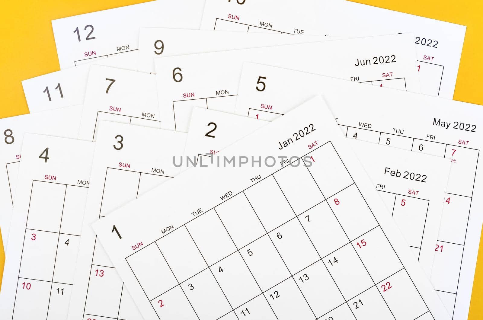 Many blank monthly 2022 calendar sheet on yellow background.