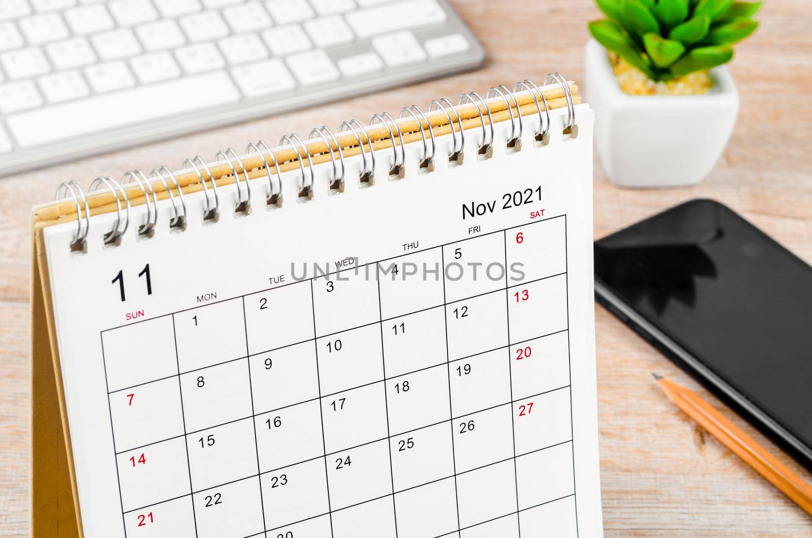 The november 2021 desk calendar on wooden table.