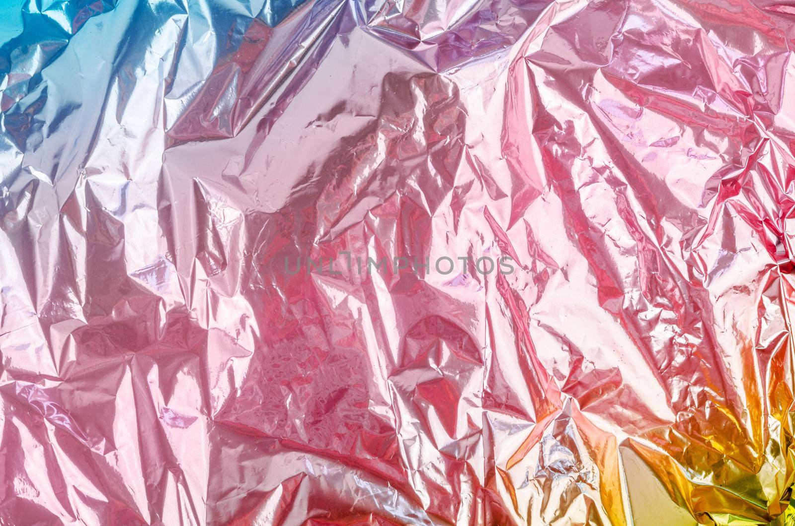 Colourful foil background with shiny crumpled surface for texture background.