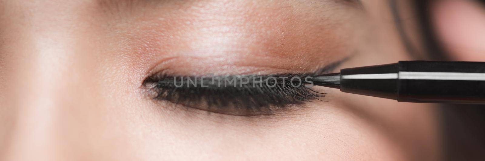 Woman appling black eye liner