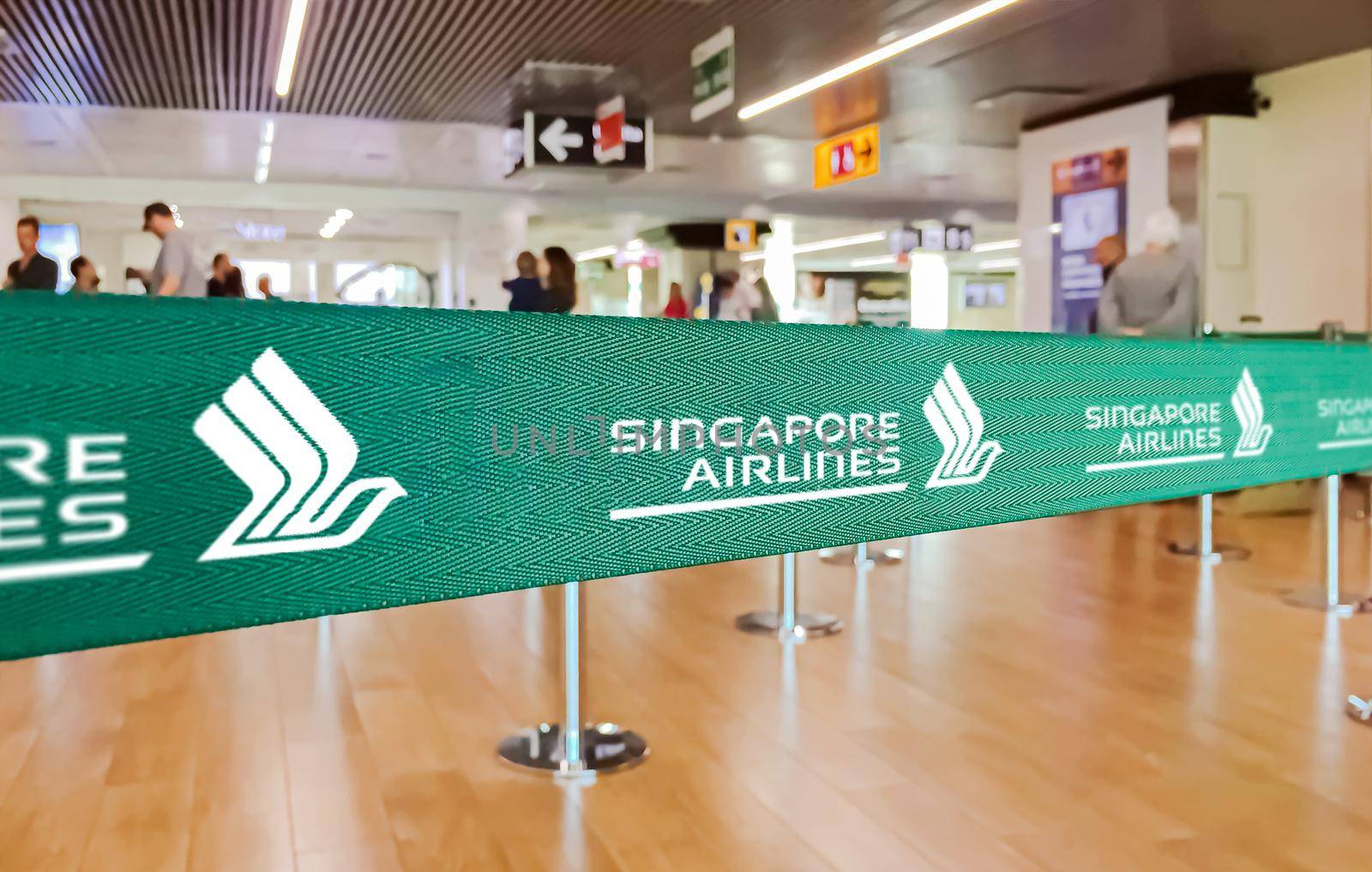 Fiumicino, Italy, July 2019: green ribbon barrier with the Singapore Airlines logo inside the Leonardo da Vinci international airport in Rome Fiumicino in Italy