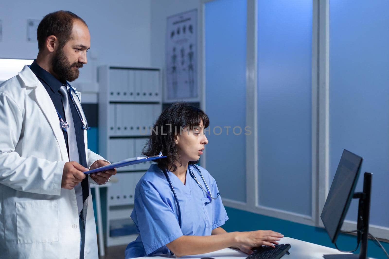 Medical team of workers looking at monitor for healthcare by DCStudio