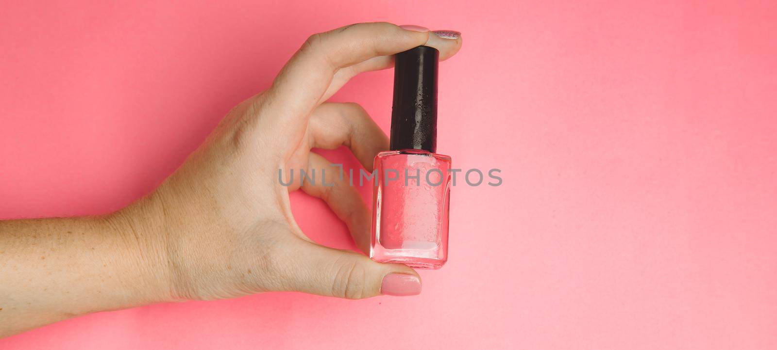 Nail polish in a woman's hand copy space. Article about manicure. Gel polish. Hand care . by alenka2194