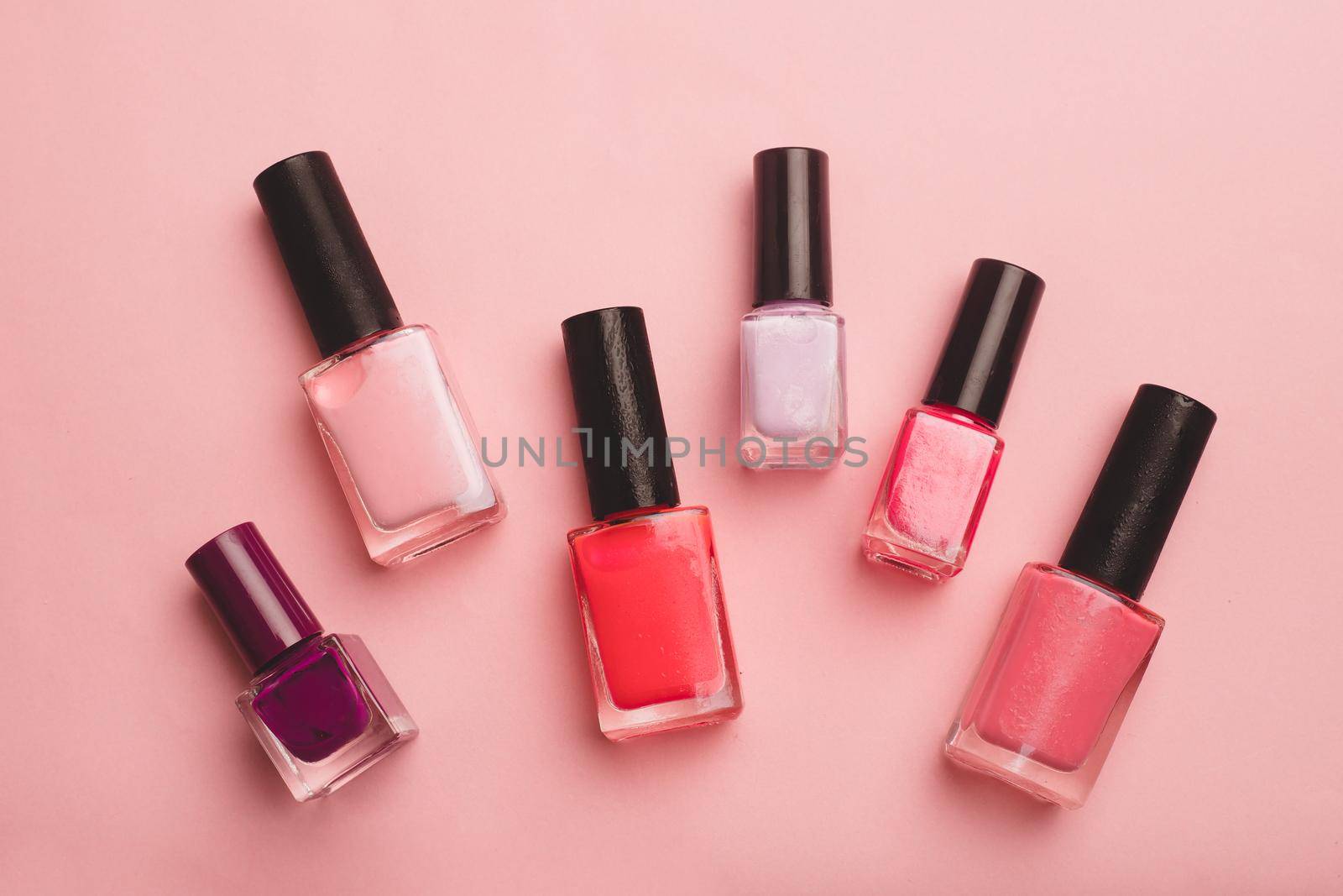 Pink nail polish on a pink copy space background. An article about nail polishes. Gel polish. An article about cosmetics. Decorative cosmetics . Pink background