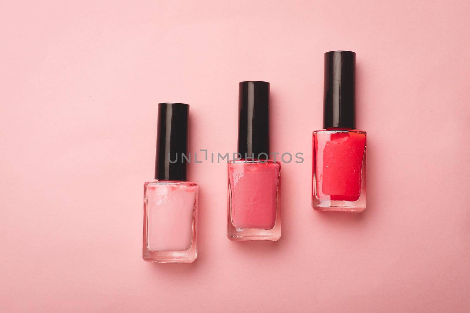 Pink nail polish on a pink copy space background. An article about nail polishes. Gel polish. An article about cosmetics. Decorative cosmetics . by alenka2194