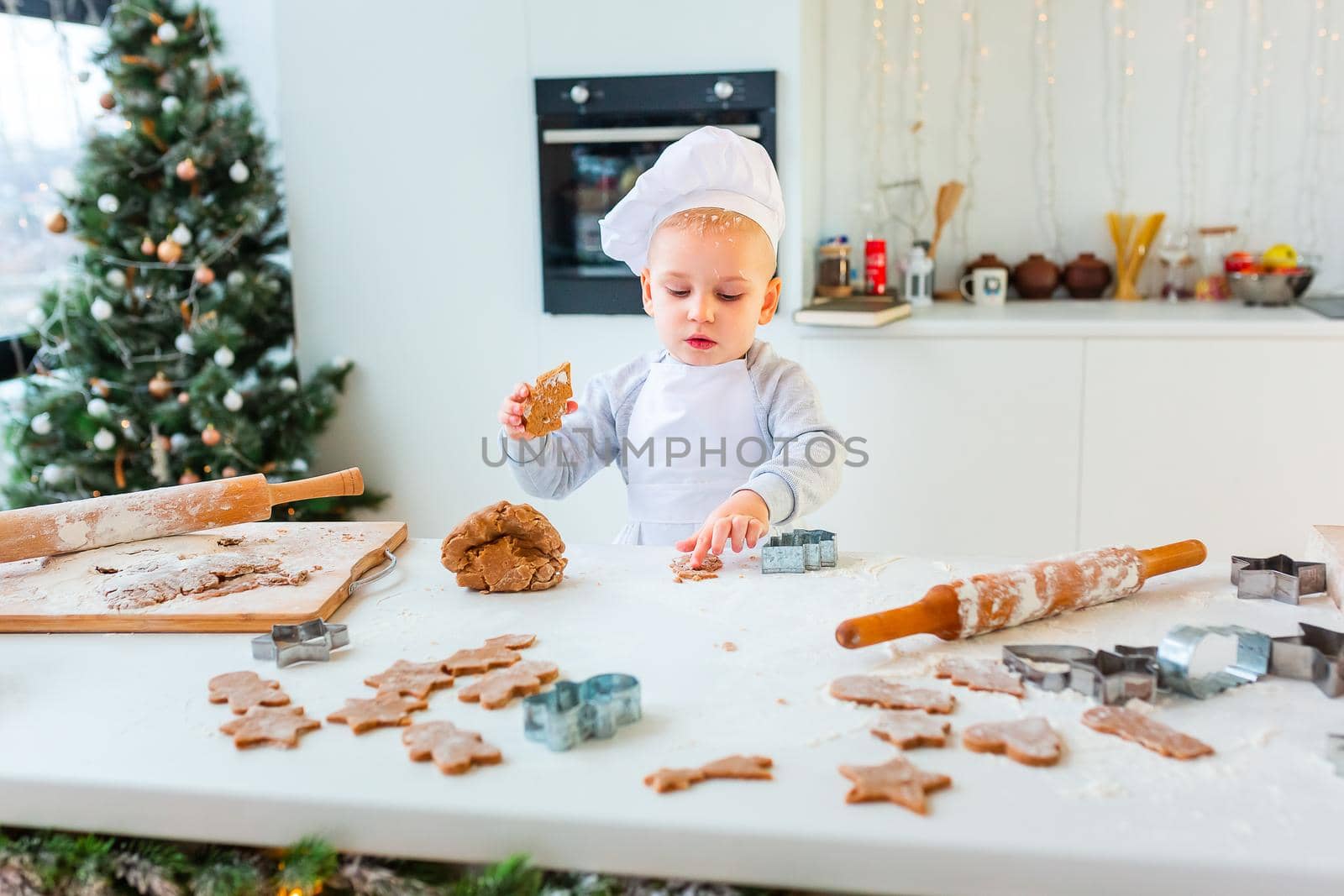 Cute little boy making gingerbread, cutting cookies of gingerbread dough. Christmas bakery. Festive food, cooking process, family culinary, Christmas and New Year traditions concept