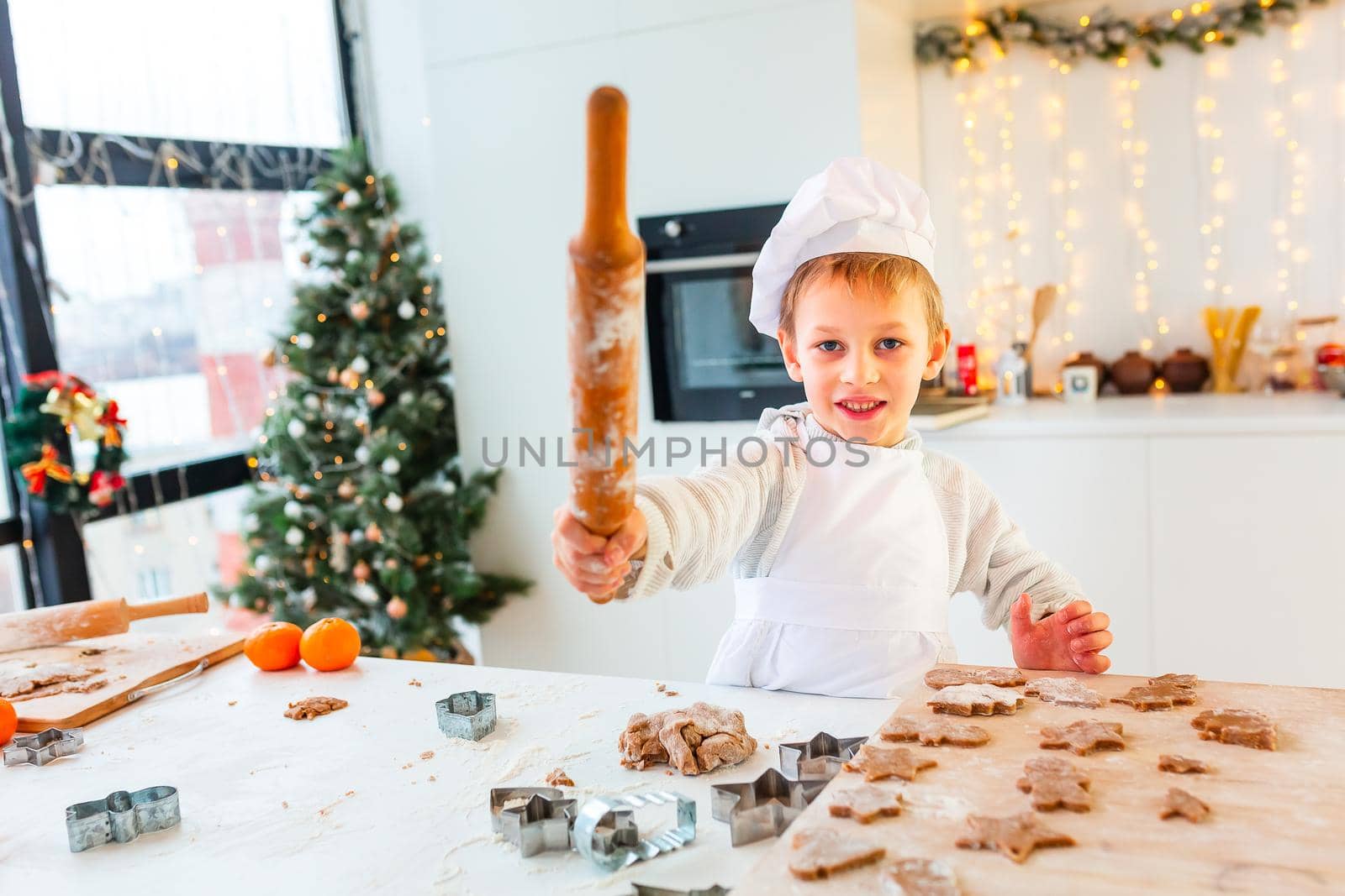 Cute little boy making gingerbread, cutting cookies of gingerbread dough. Christmas bakery. Festive food, cooking process, family culinary, Christmas and New Year traditions concept