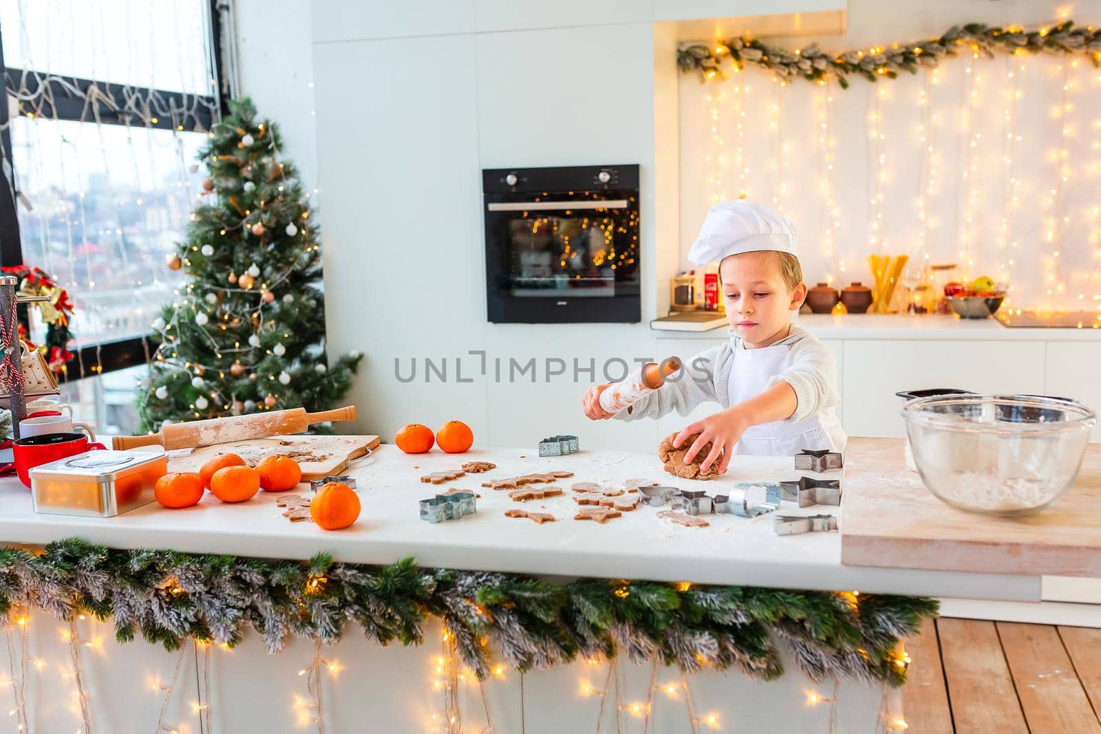 Cute little boy making gingerbread, cutting cookies of gingerbread dough. Christmas bakery. Festive food, cooking process, family culinary, Christmas and New Year traditions concept