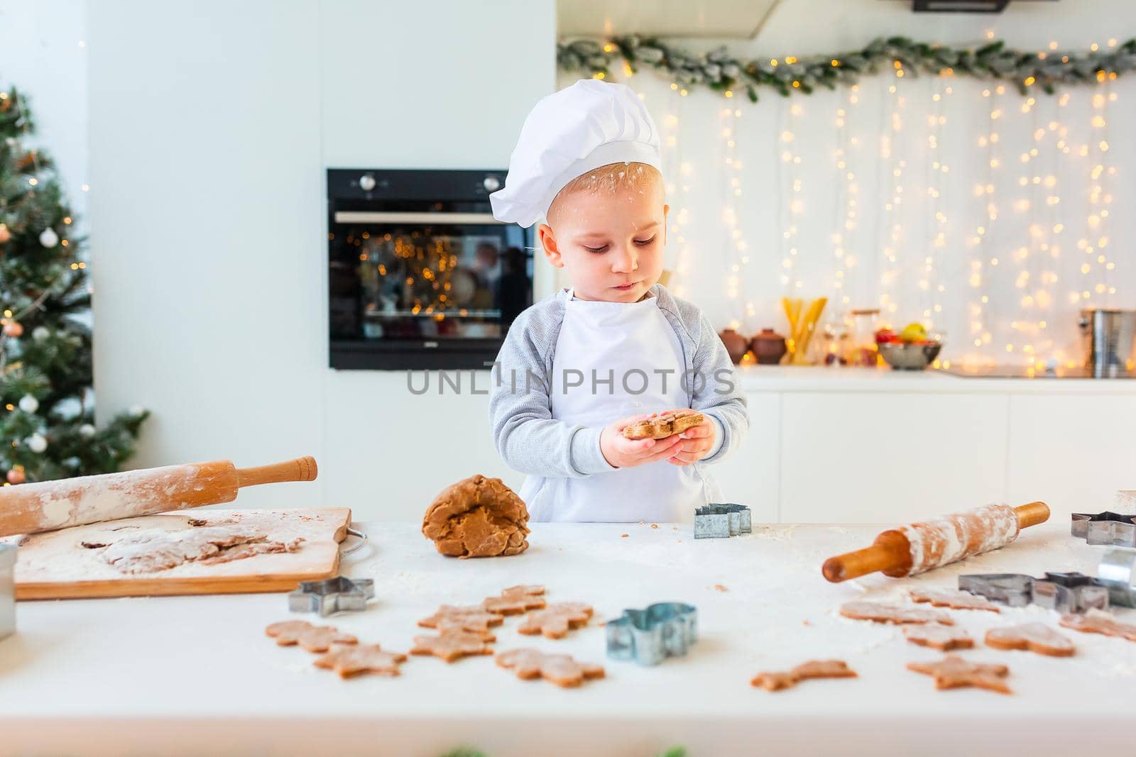 Cute little boy making gingerbread, cutting cookies of gingerbread dough. Christmas bakery. Festive food, cooking process, family culinary, Christmas and New Year traditions concept