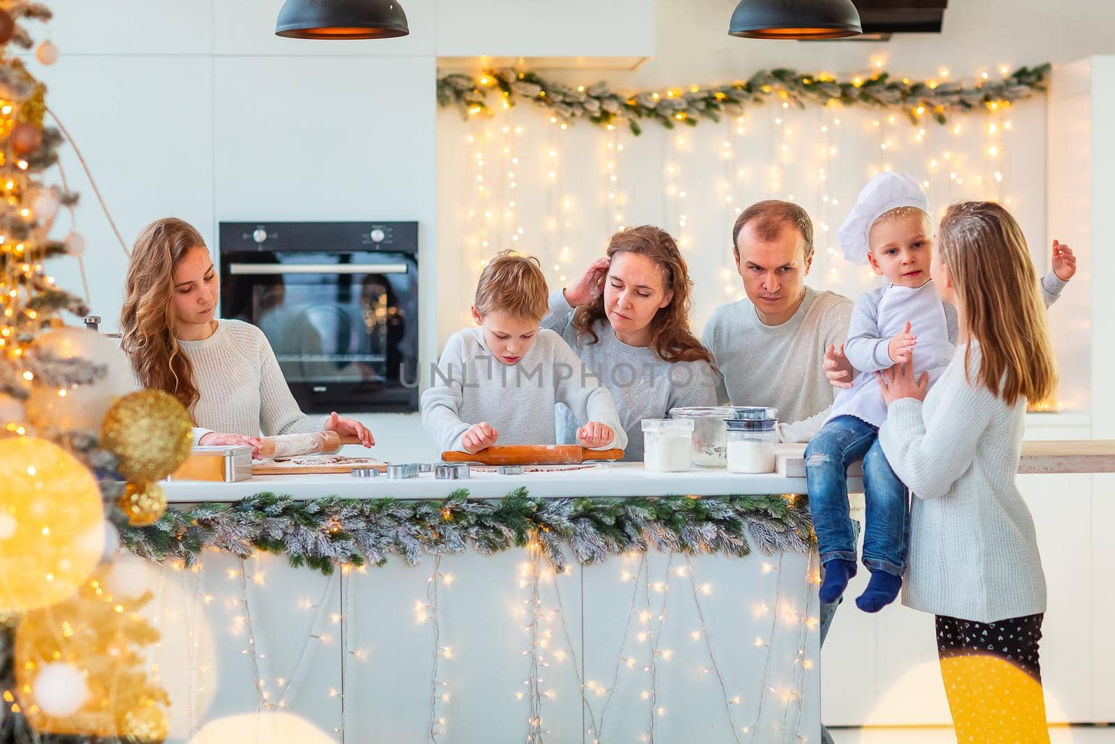 Big happy family making gingerbread, cutting cookies of gingerbread dough, having fun. Festive food, cooking process, family culinary, Christmas and New Year traditions concept. Christmas bakery.