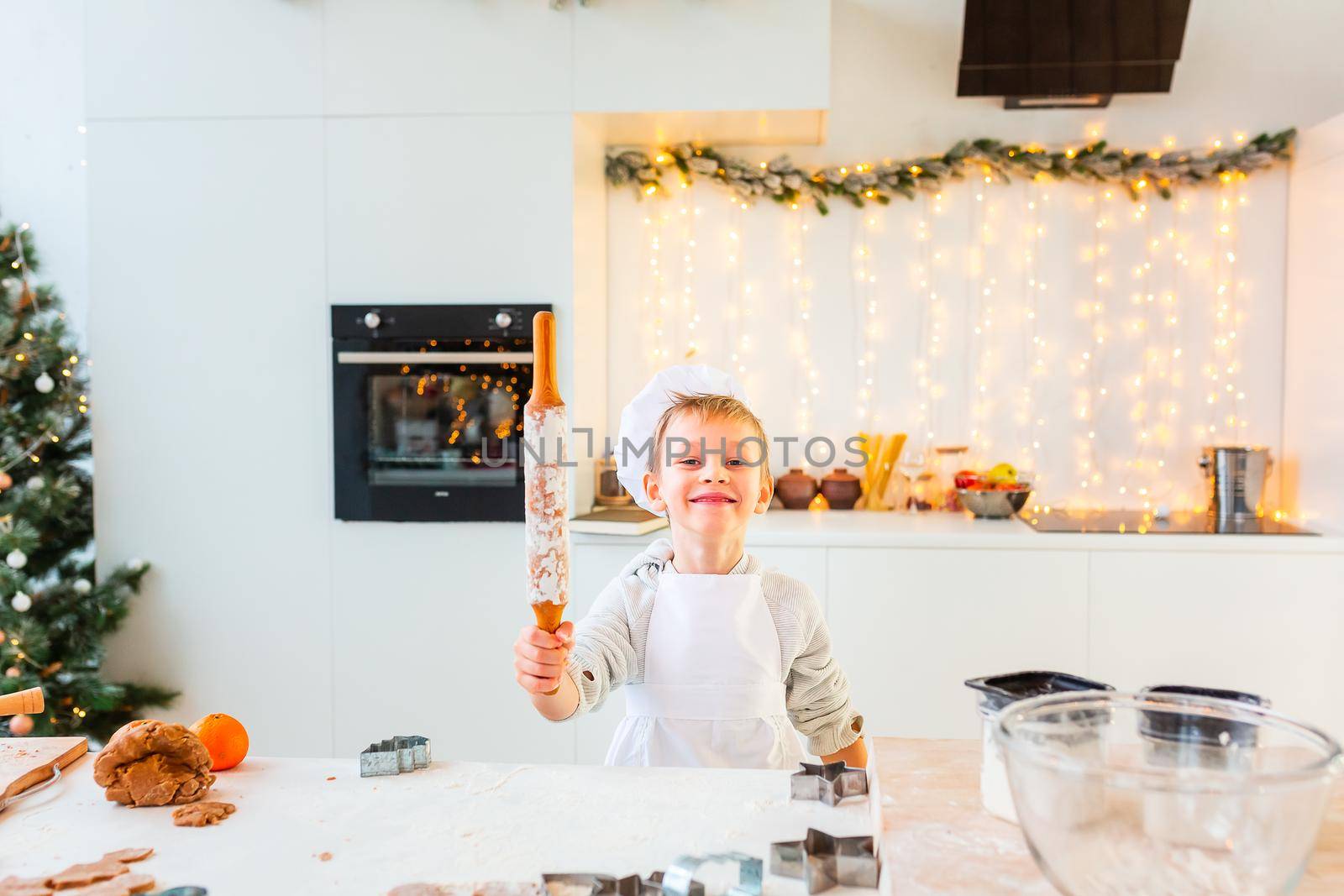 Cute little boy making gingerbread, cutting cookies of gingerbread dough. Christmas bakery. Festive food, cooking process, family culinary, Christmas and New Year traditions concept