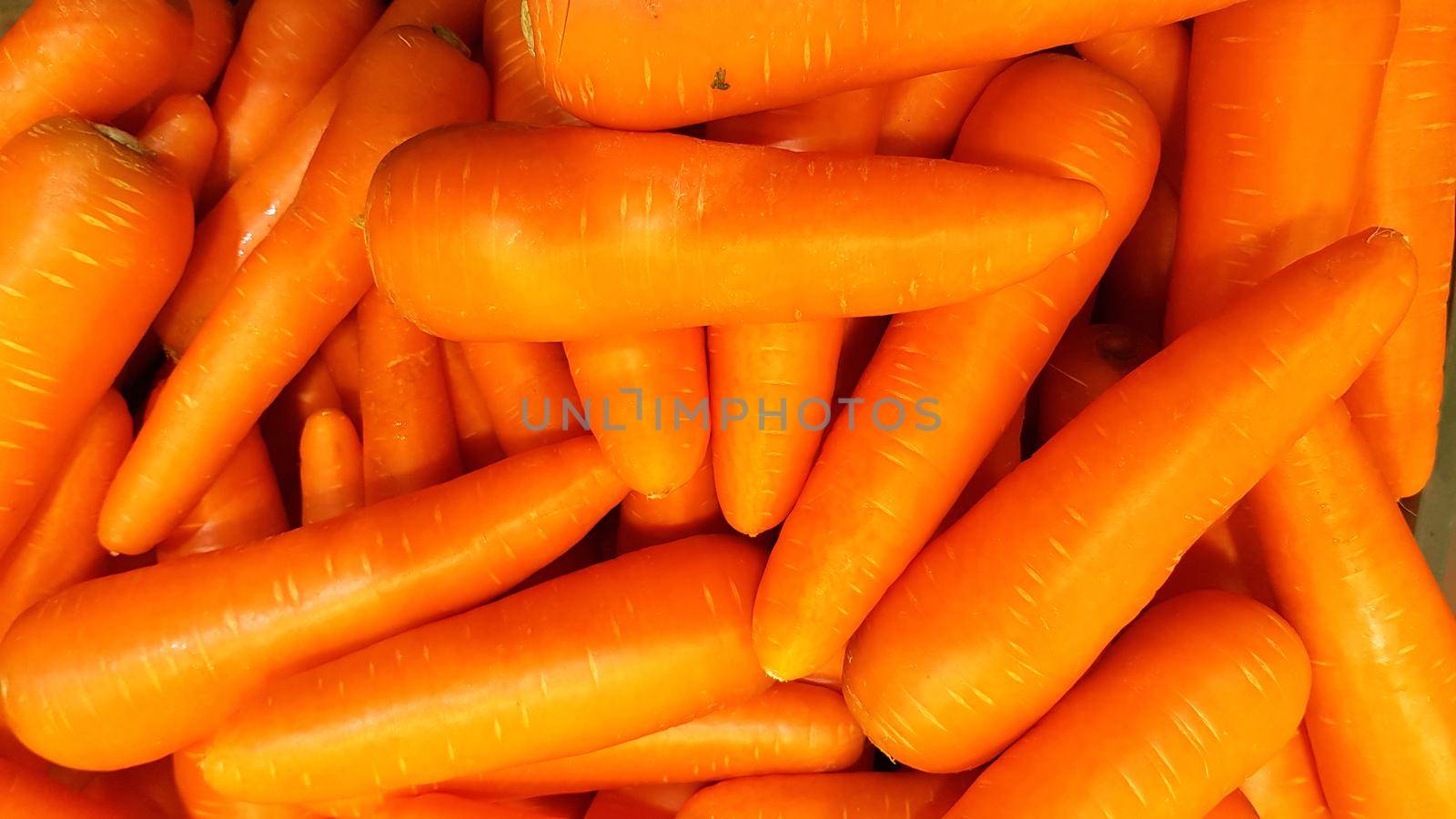Many carrots are placed together in the shop for sale.