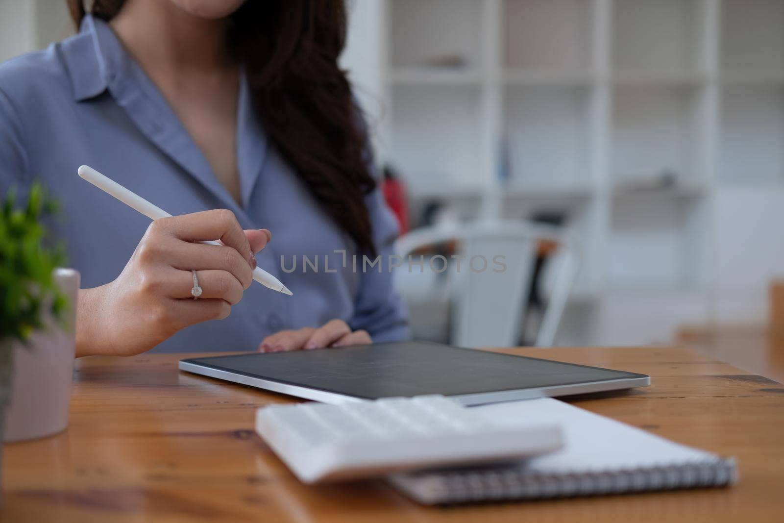 Close up business accountant using digital tablet for calculate finance on wooden desk.