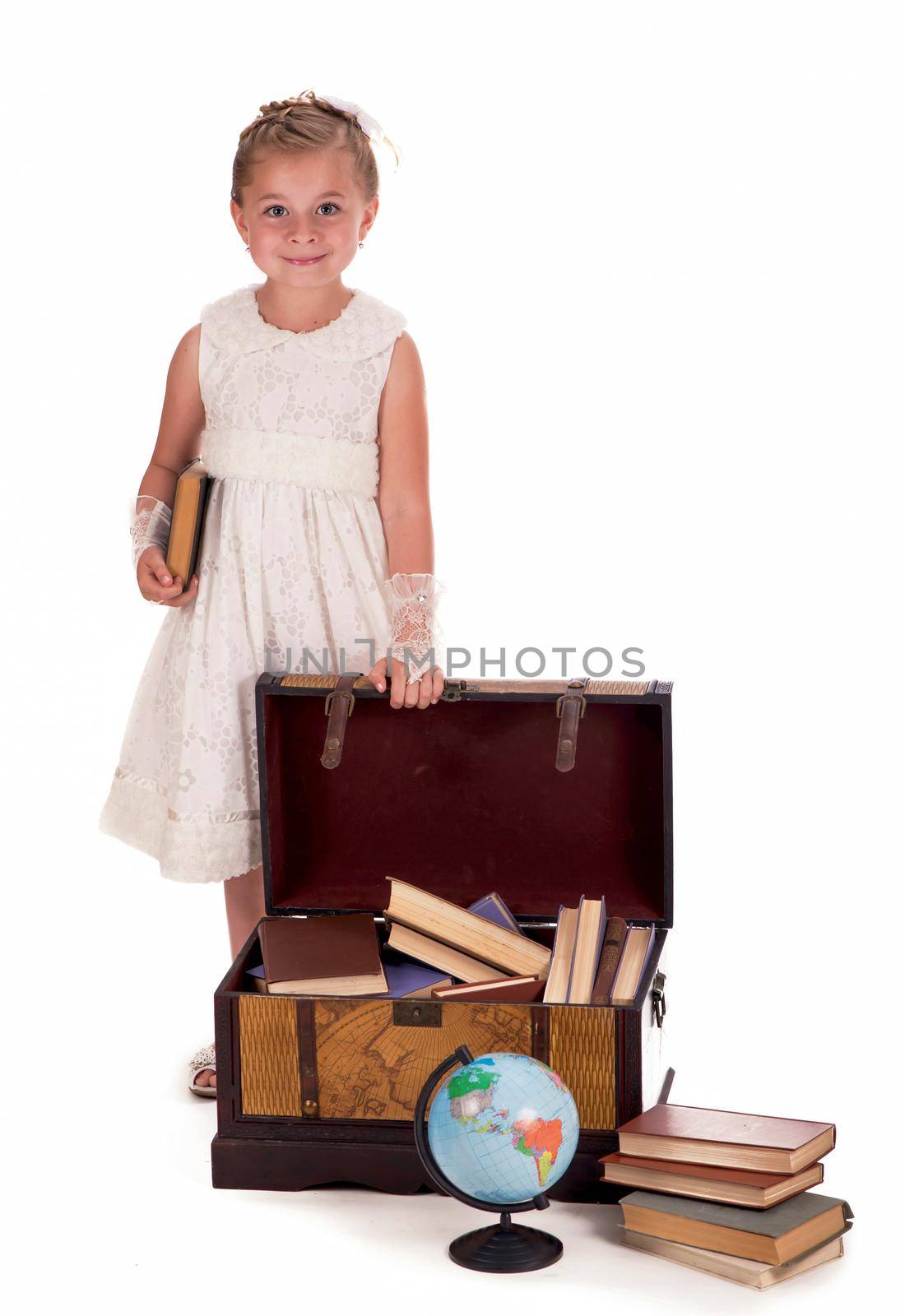 girl and a chest with books. little girl looking inside a trunk with surprise on white background by aprilphoto