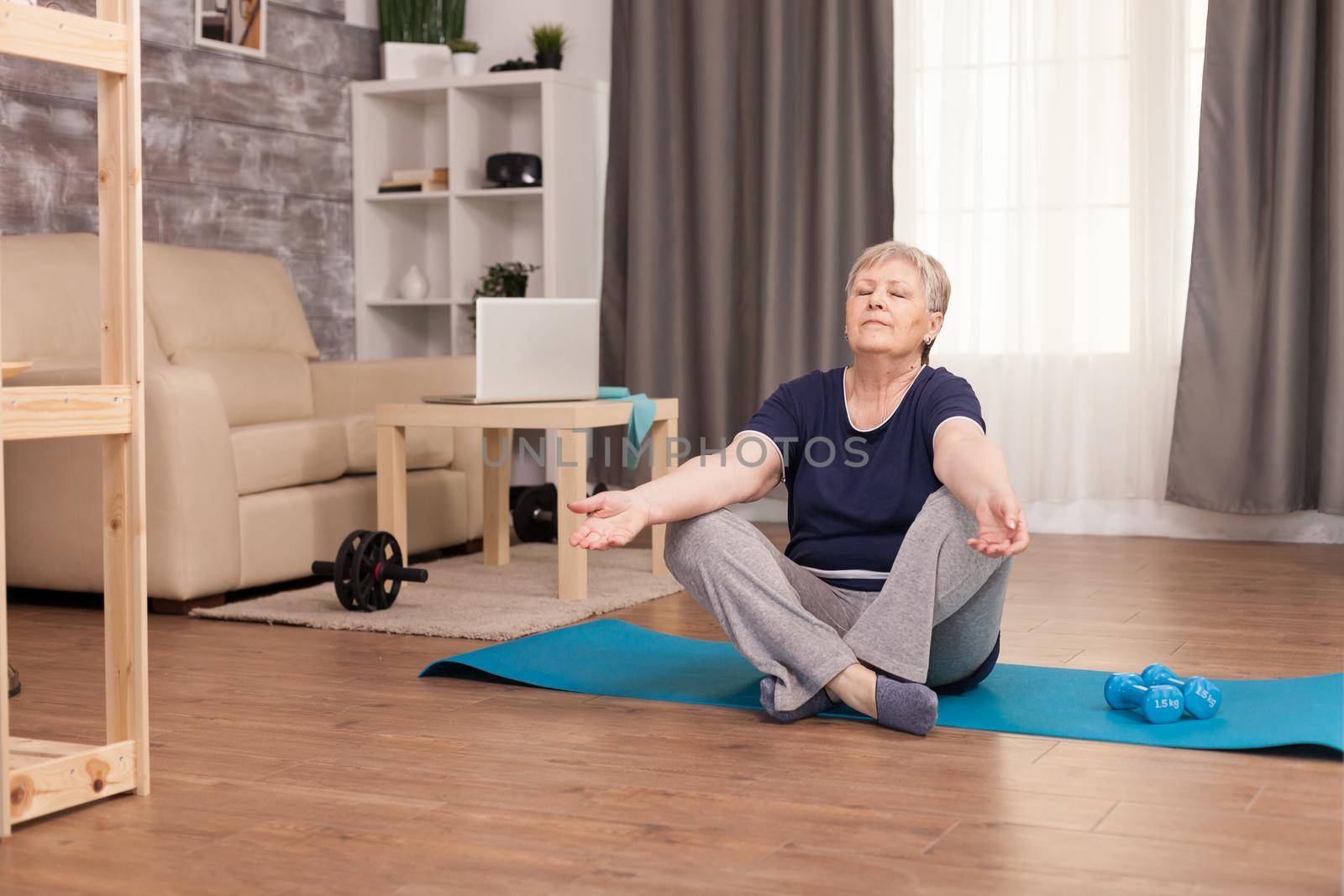 Elderly woman meditating by DCStudio