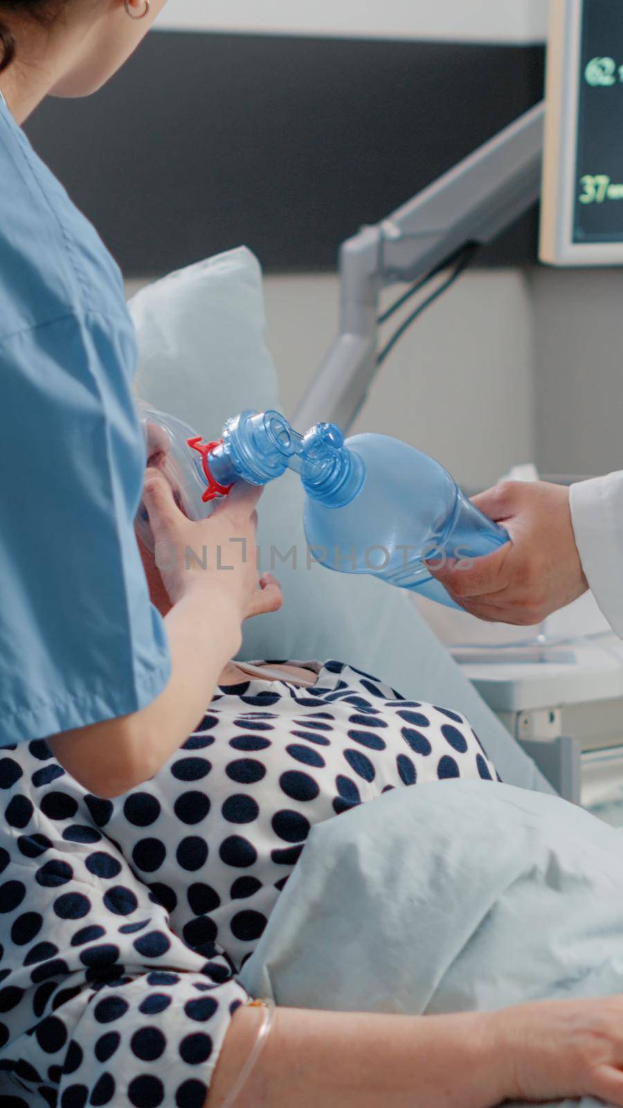 Patient with respiratory problem asking for medical help in hospital ward bed. Retired woman with disease receiving assistance from doctor and nurse with oxygen tube and oximeter.