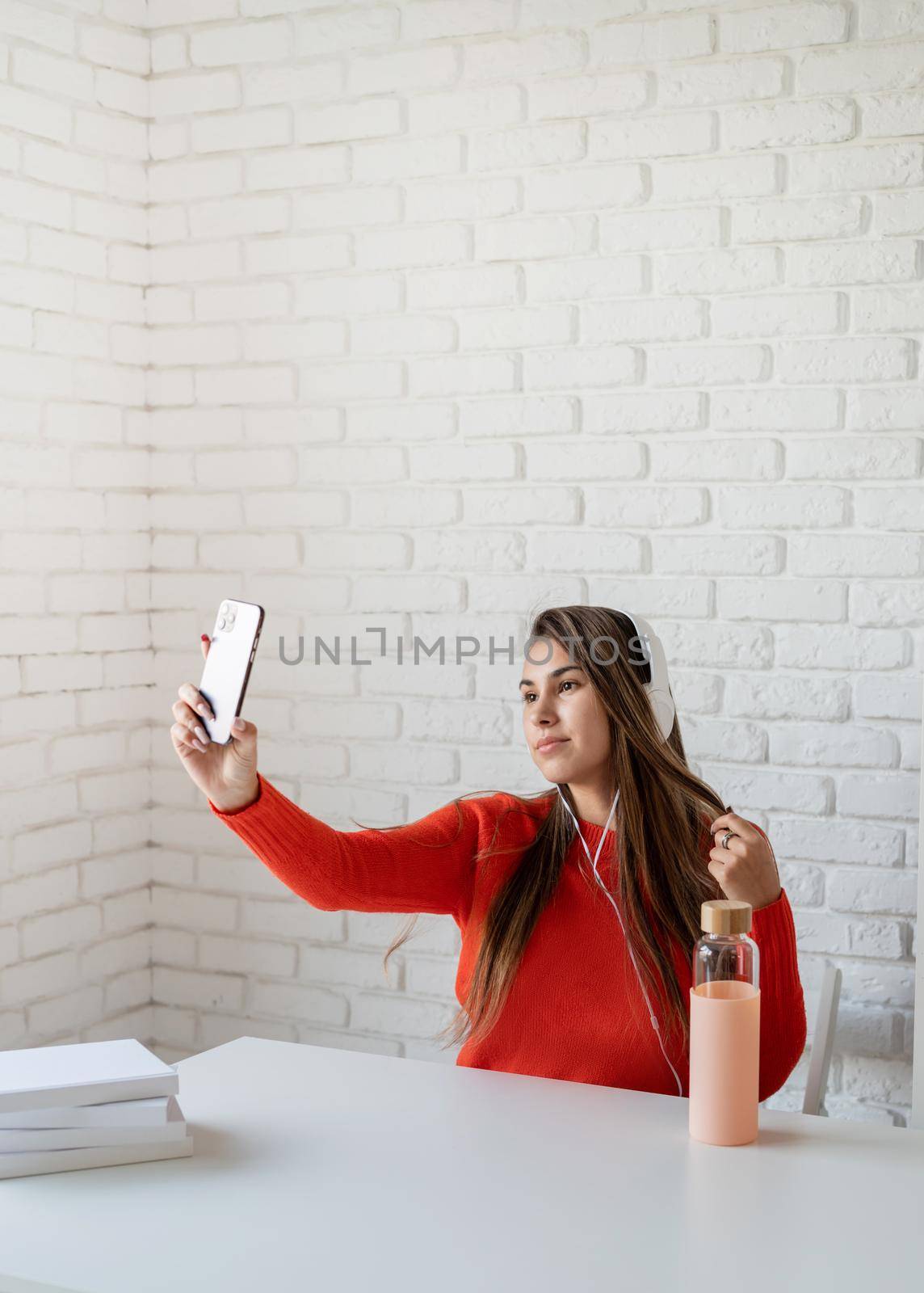 Young caucasian woman listening to the music taking selfie by Desperada