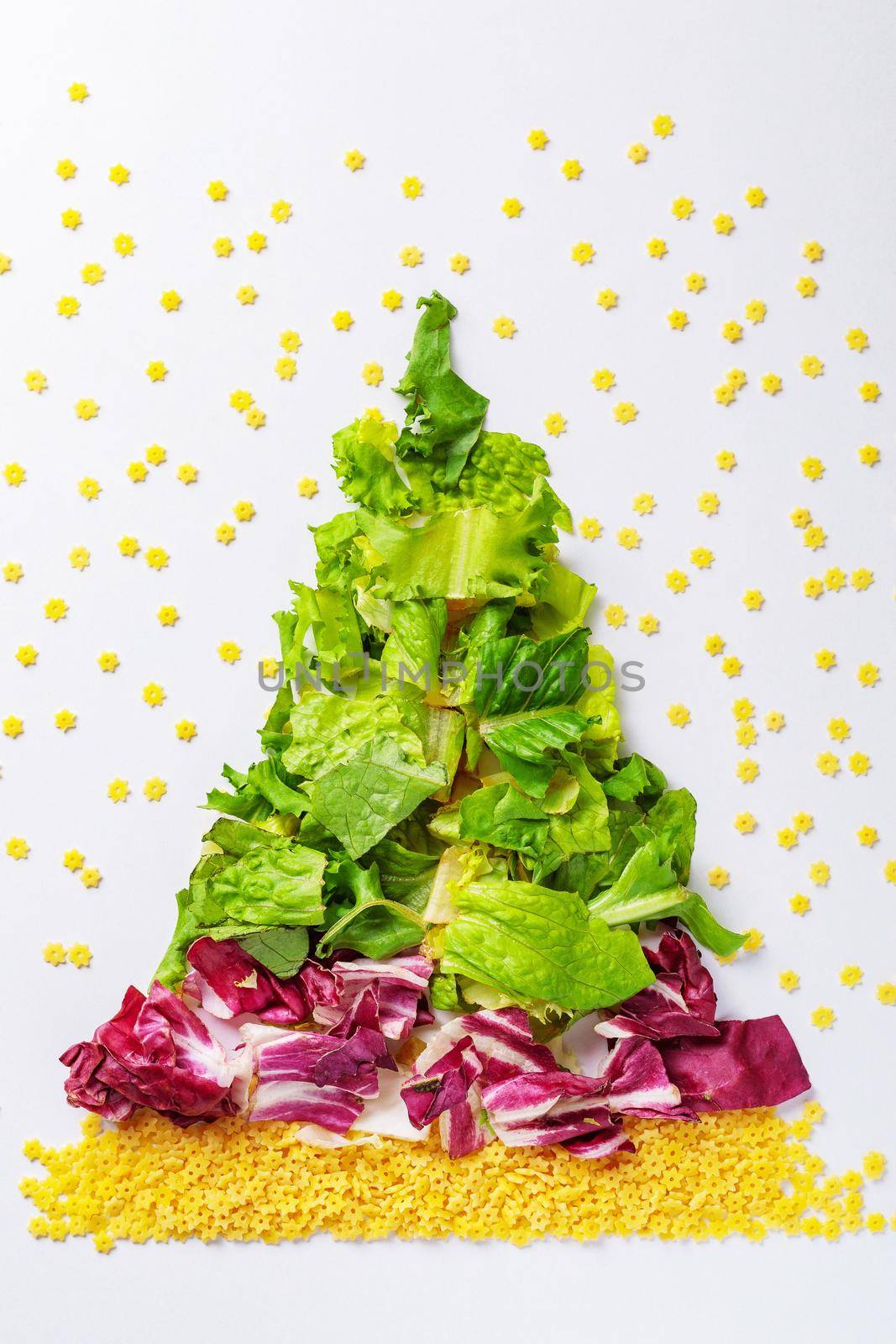 Christmas tree made from green salad products, cabbage, raw pasta. View from above