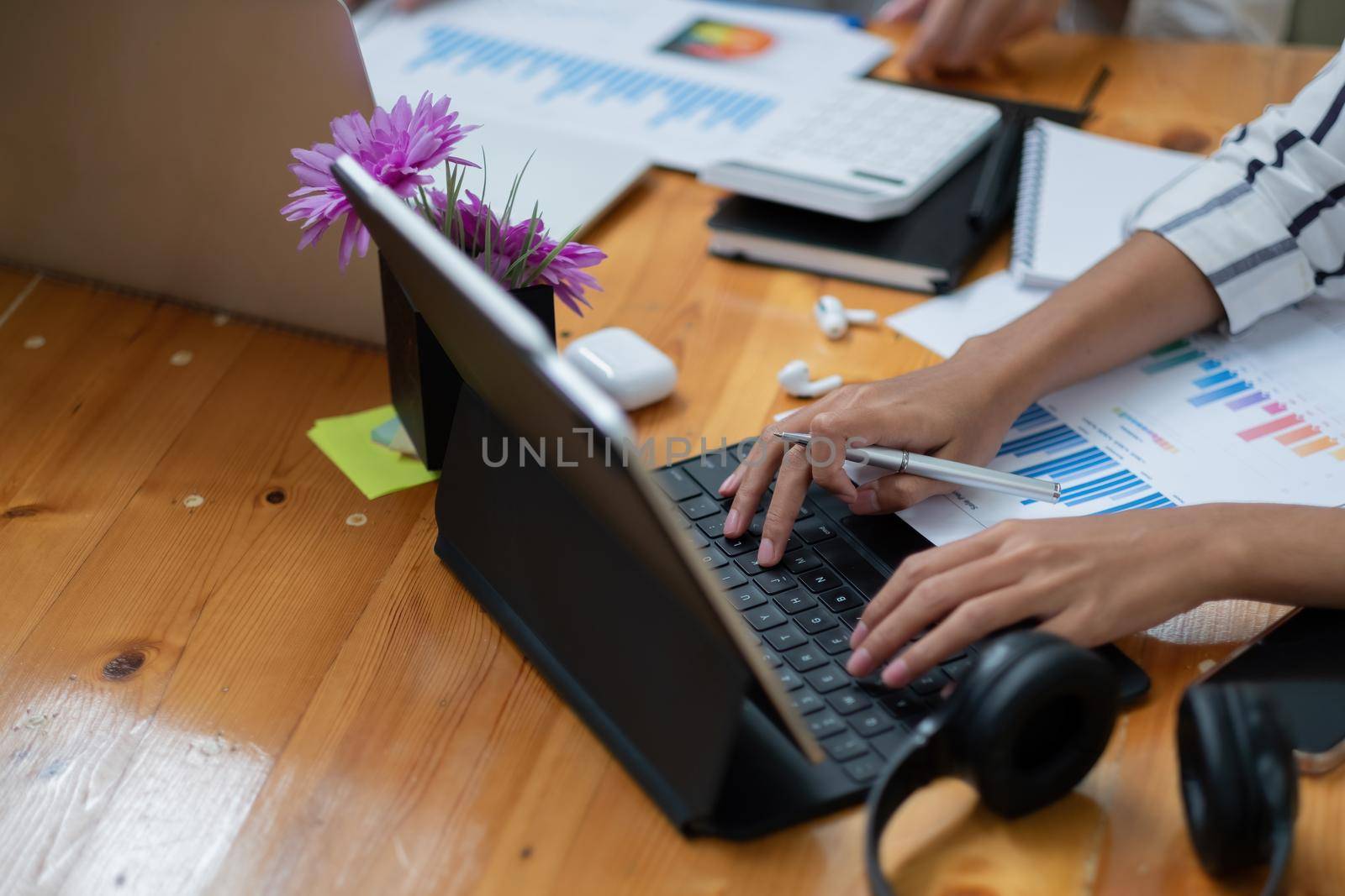 Close up of student girl hands comparing notes on digital tablet sitting on a desk. female using tablet at cafe