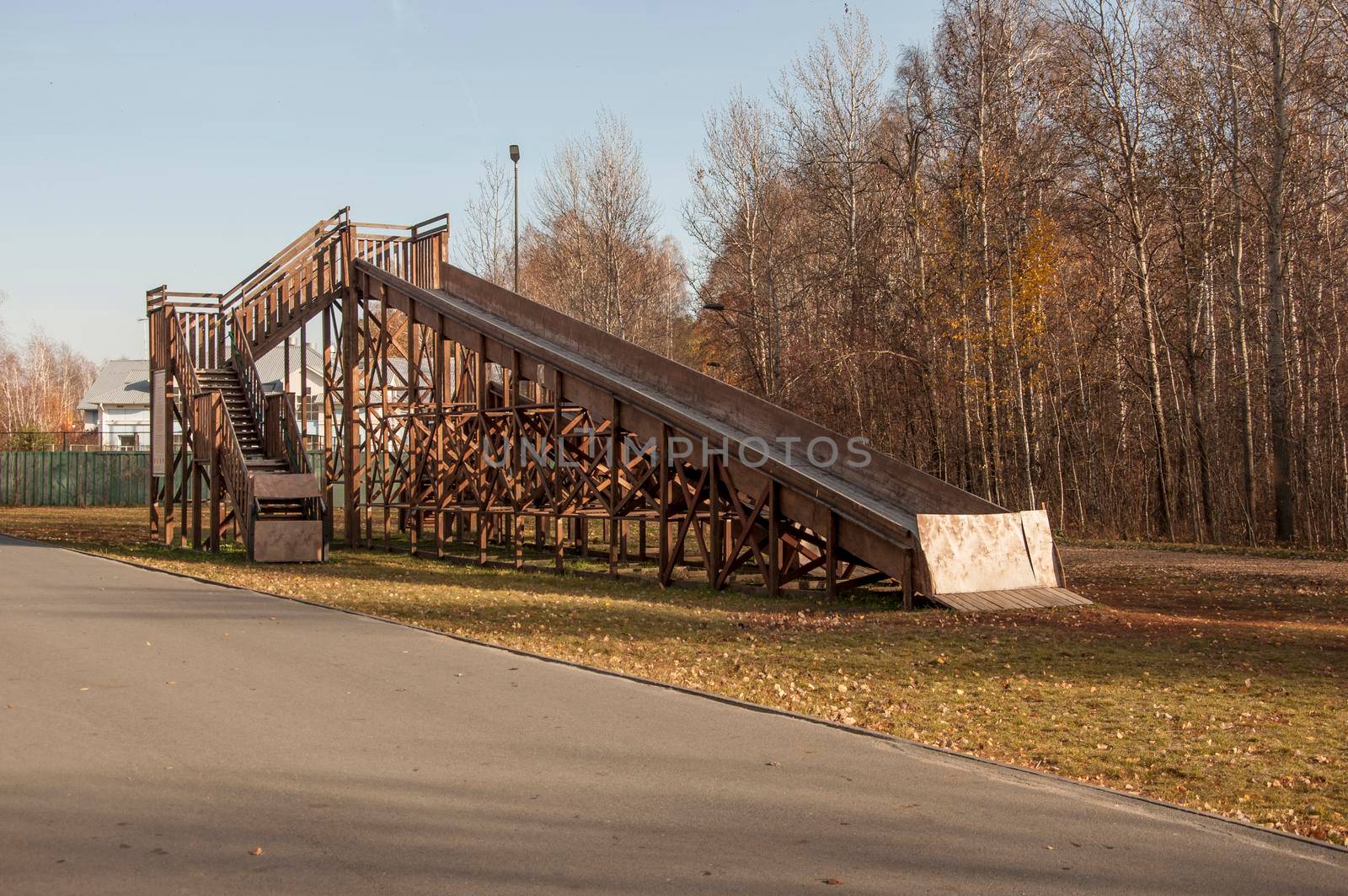 A large wooden slide for sleds. Empty inactive in the autumn