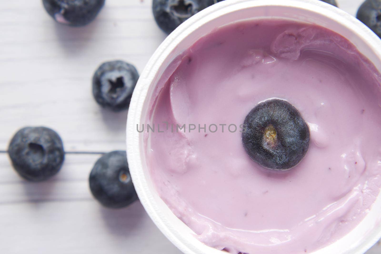close up of fresh yogurt with blue berry in a bowl .
