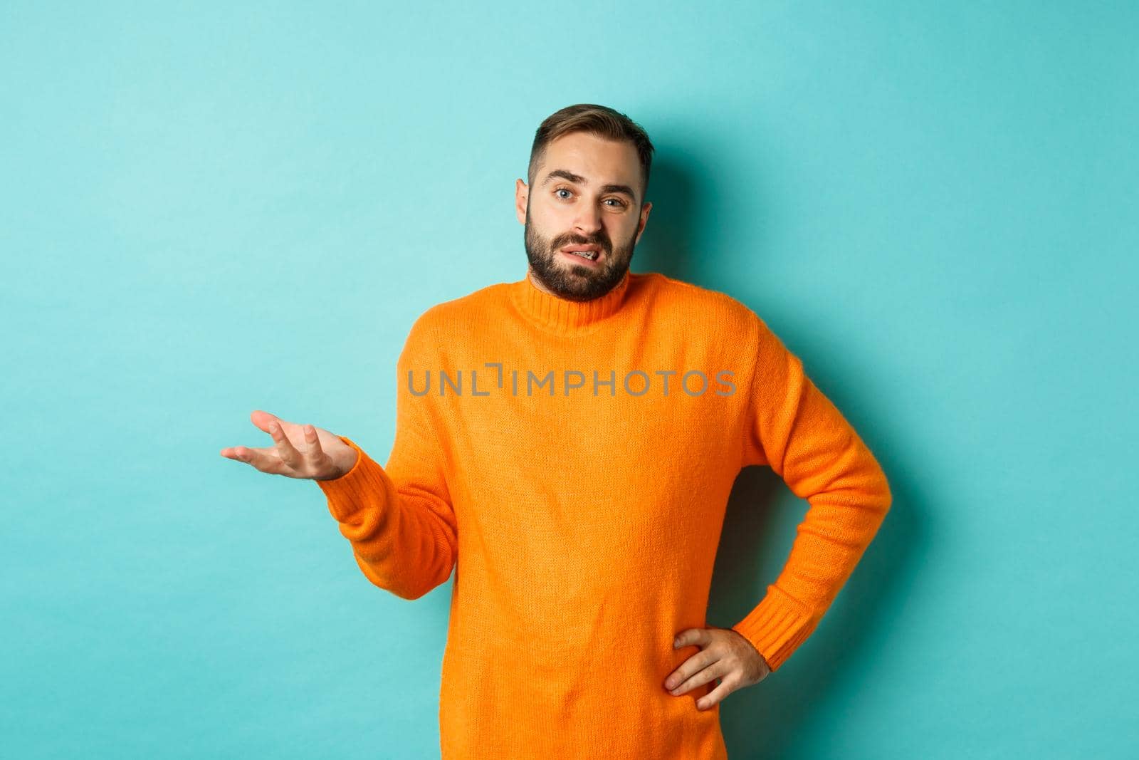 Careless and indifferent guy shrugging, looking unbothered, dont know anything, standing over light blue background.