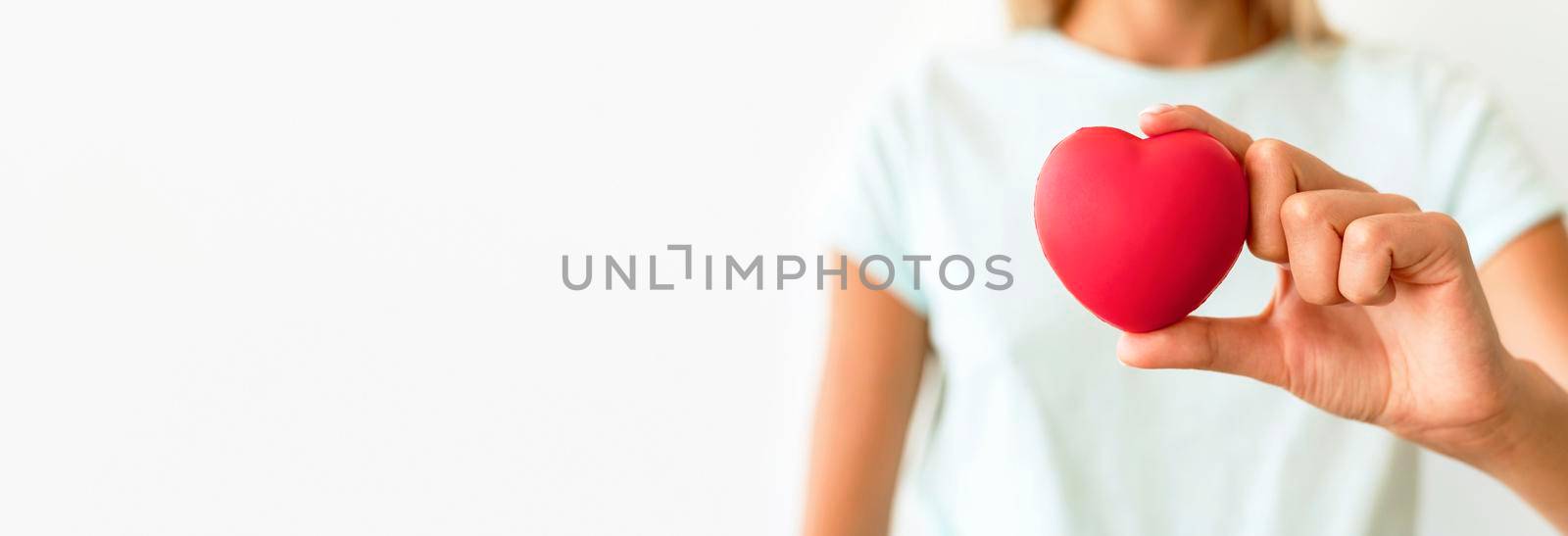 front view defocused woman holding heart shape. High resolution photo