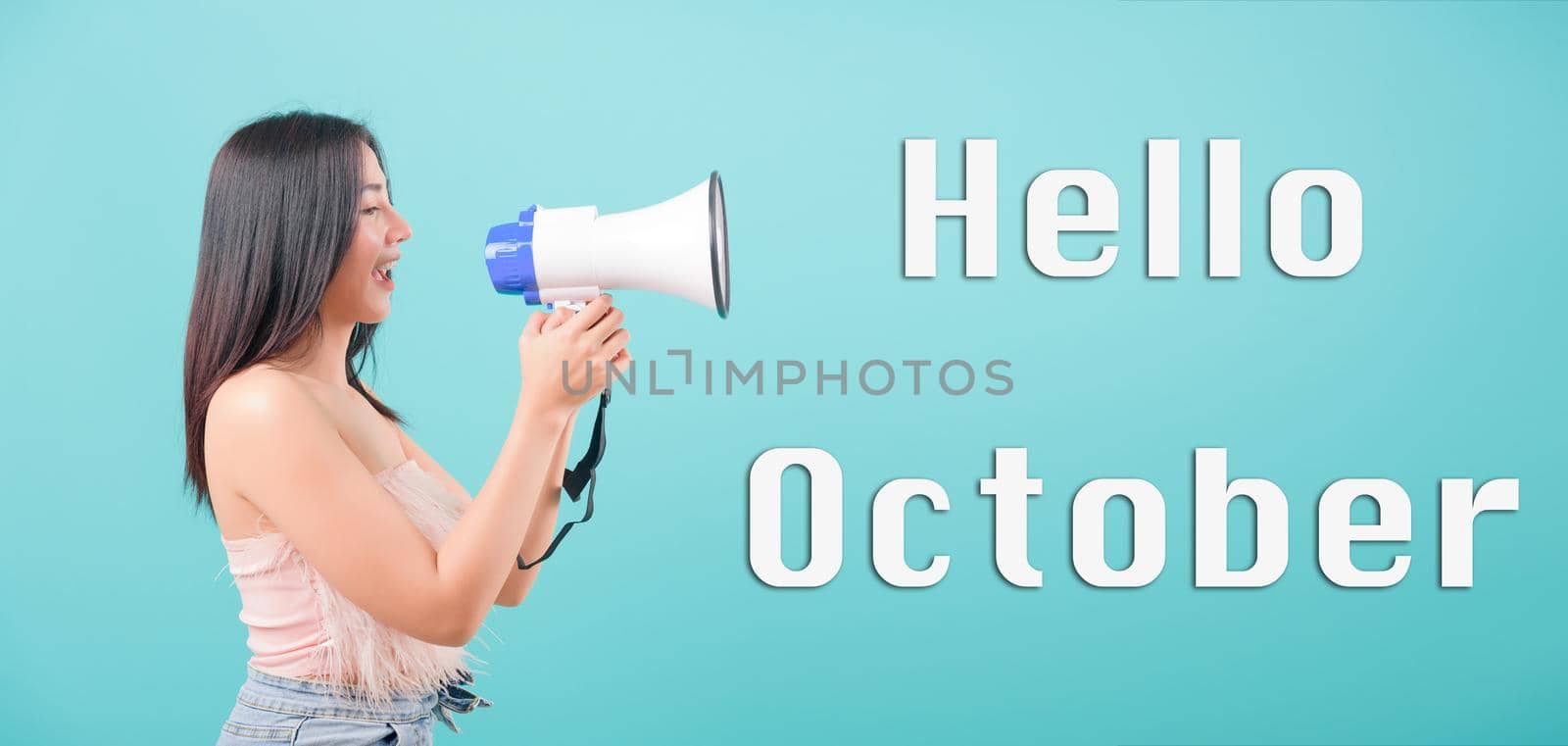 Hello October, Asian happy portrait beautiful young woman standing smile her holding her Shouting through a megaphone by Sorapop